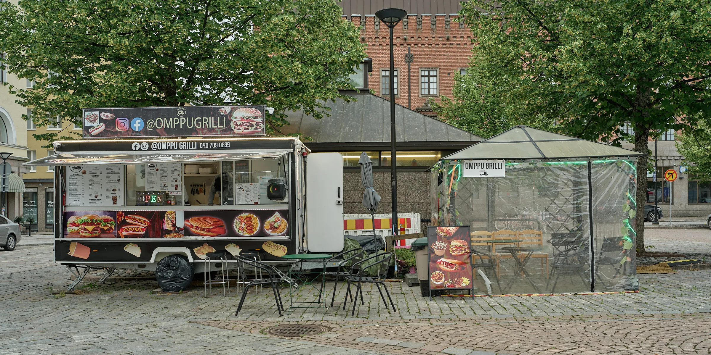 Snack trailer with empty tables and chairs on a paved square