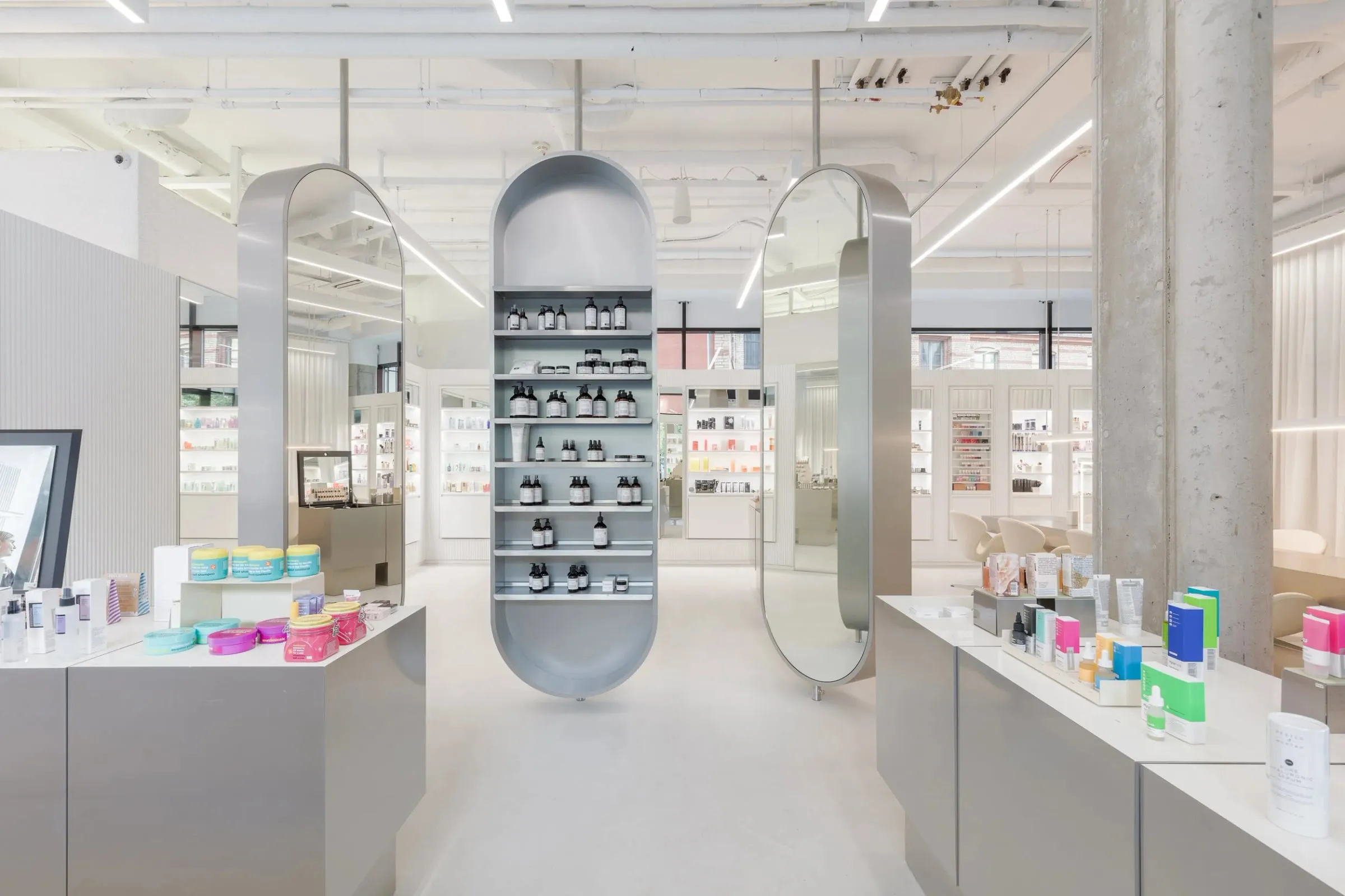 Verkaufsfläche im Zalando Beauty Store Berlin, helle Regalmodule mit Pflegeprodukten und ovale Spiegelregale auf weißem Boden