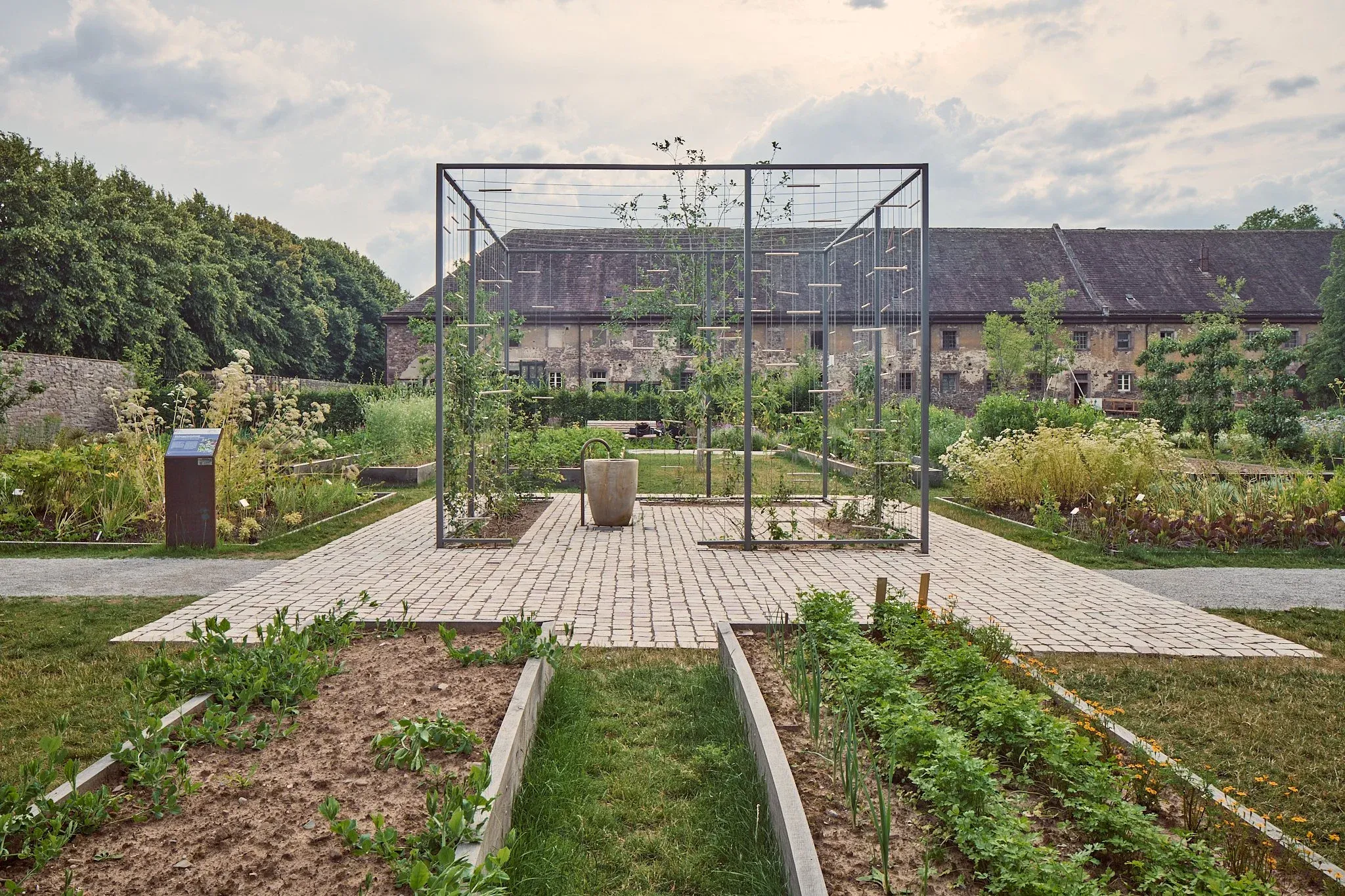 Quadratische Stahlrahmen-Konstruktion auf gepflastertem Platz im Remtergarten, alte Mauer und Gebäude im Hintergrund