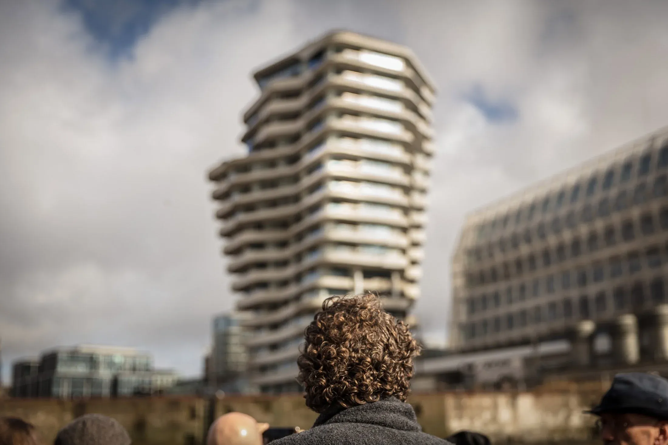 Blick über den Hinterkopf einer Person auf den Marco-Polo-Tower in der Hamburger HafenCity