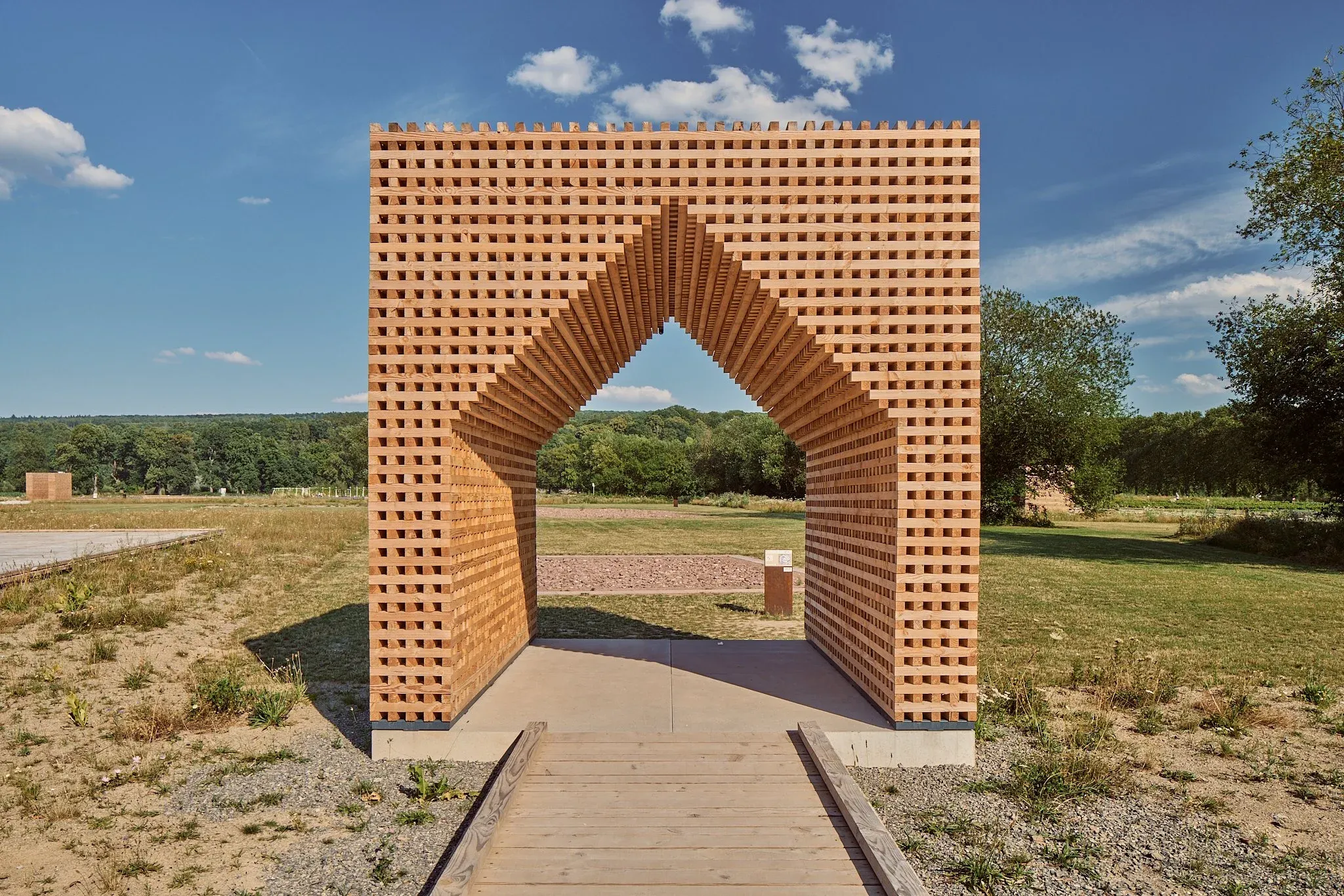 Begehbarer Backsteinpavillon mit giebelförmigem Durchgang auf der Landesgartenschau Höxter, Holzsteg im Vordergrund