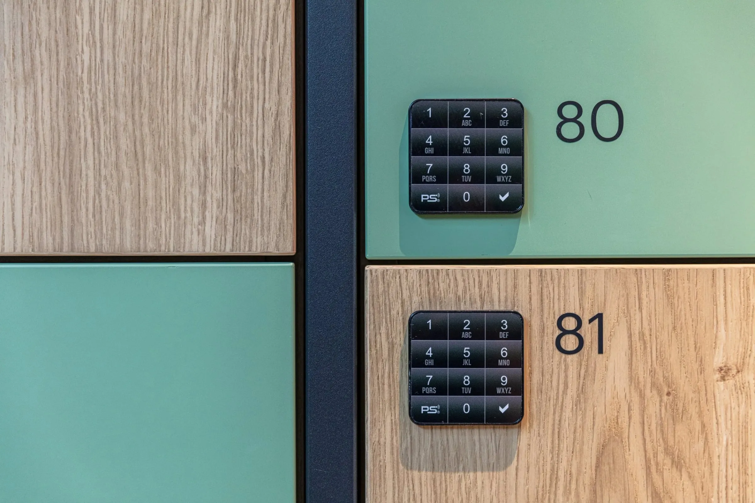 Detail zweier Schließfächer in Holz und Grün mit beleuchteten Tastenfeldern und den Nummern 80 und 81