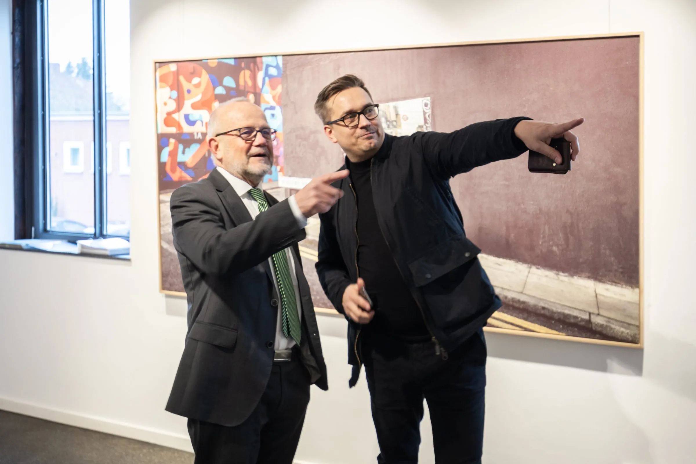 Zwei Männer im Gespräch vor einer großformatigen gerahmten Fotografie der Reihe Hidden Places