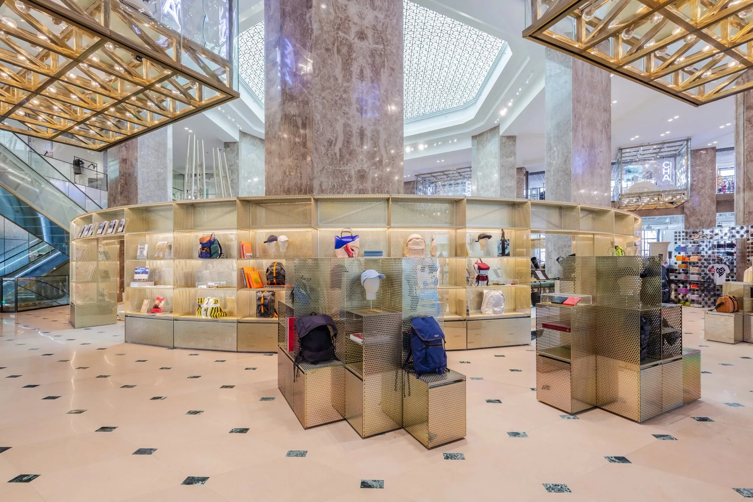 Runde goldene Präsentationsinsel mit Taschen und Accessoires unter Kuppel und Marmorsäulen, Innenraum