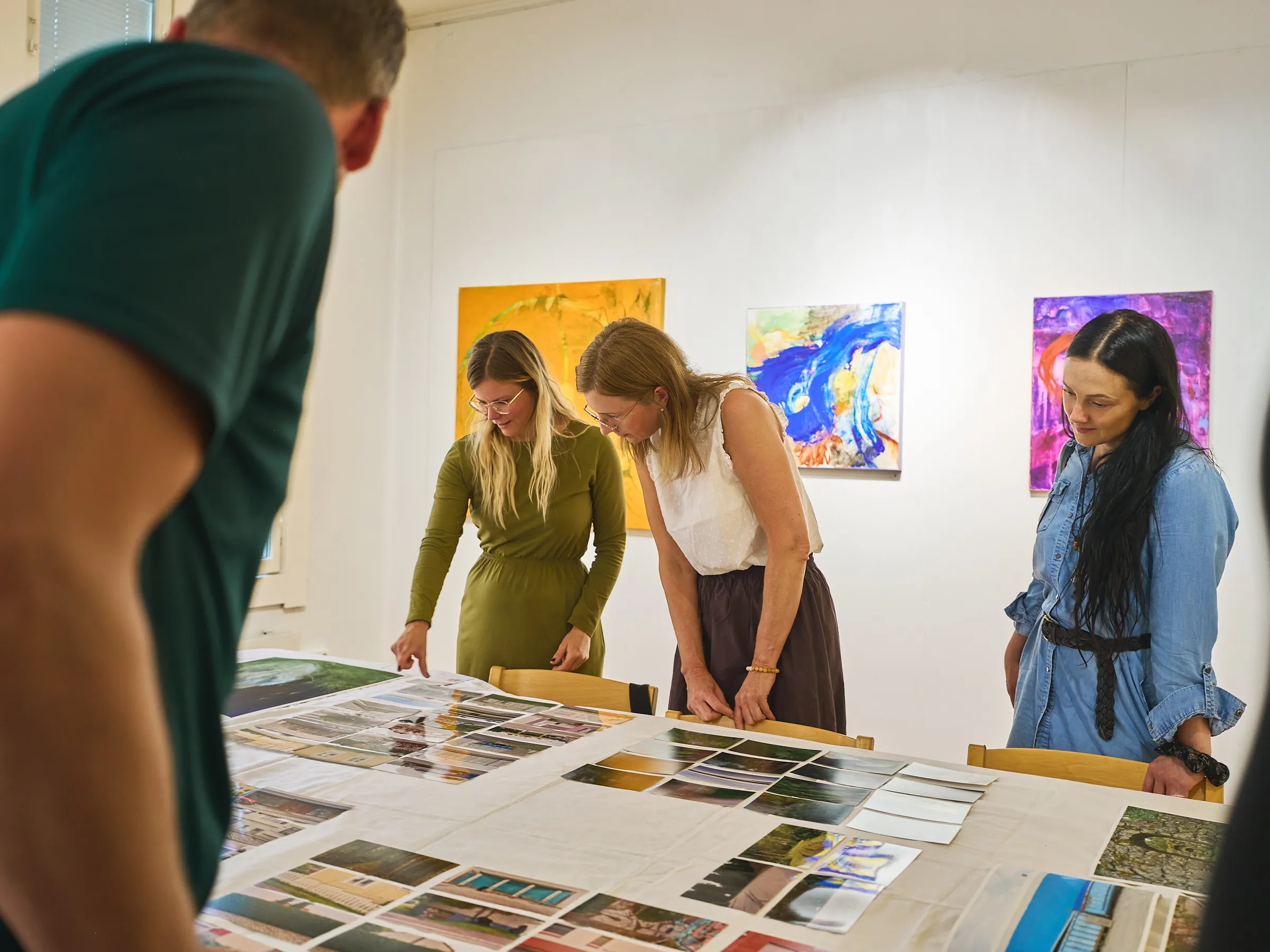 Two women at the table, another person's shoulder blurred in the foreground