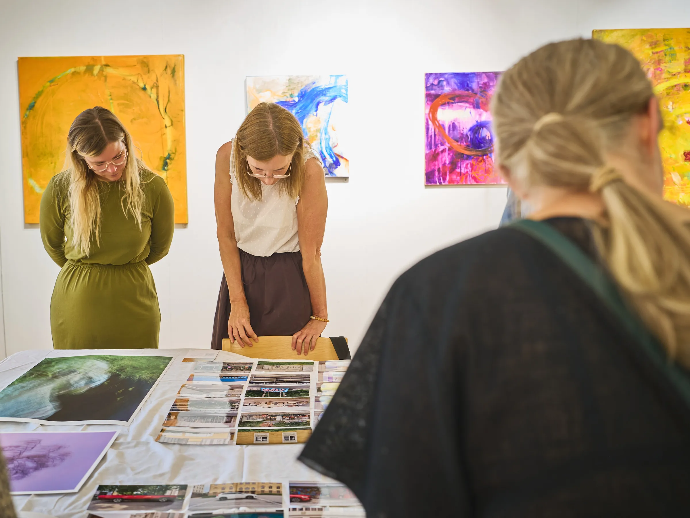 View over a shoulder onto two women looking at the pictures on the table