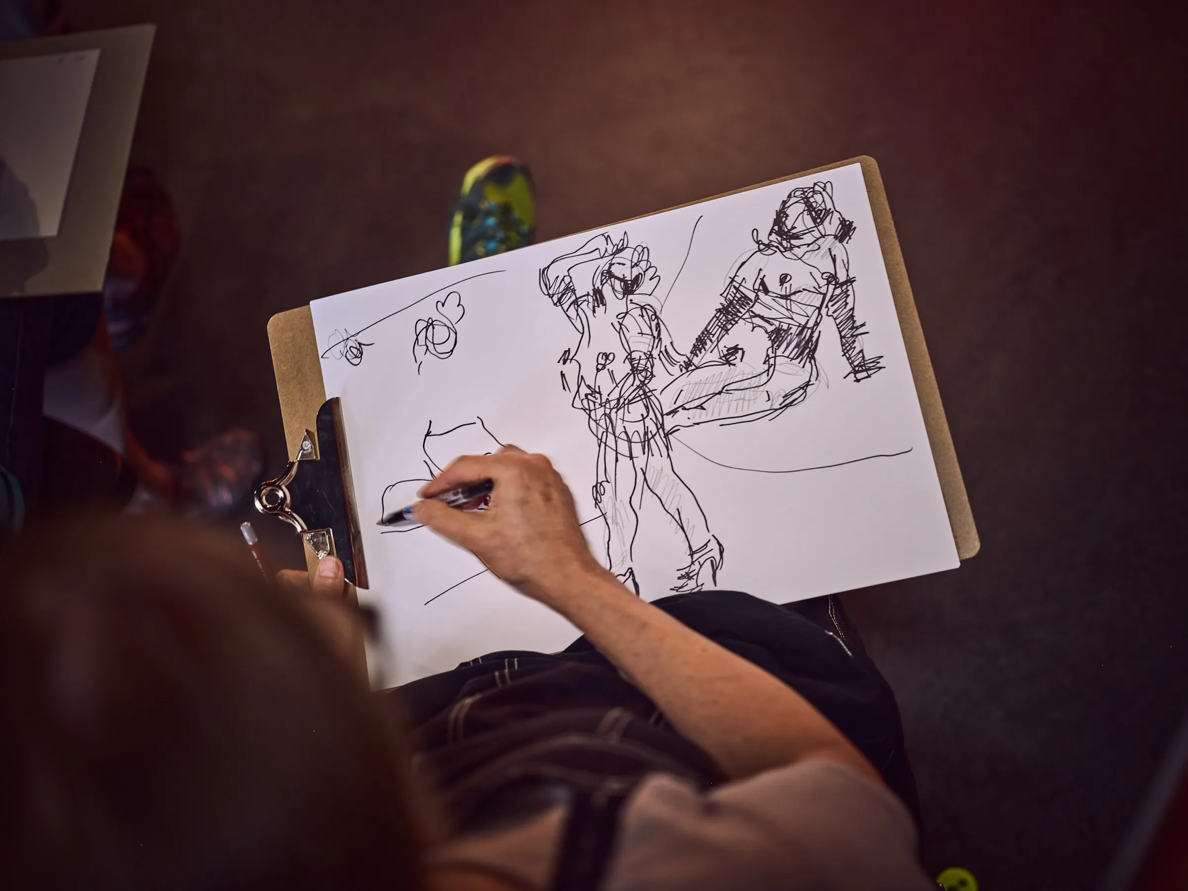 Sketchpad seen from above with quick, dynamic figure drawings in ink