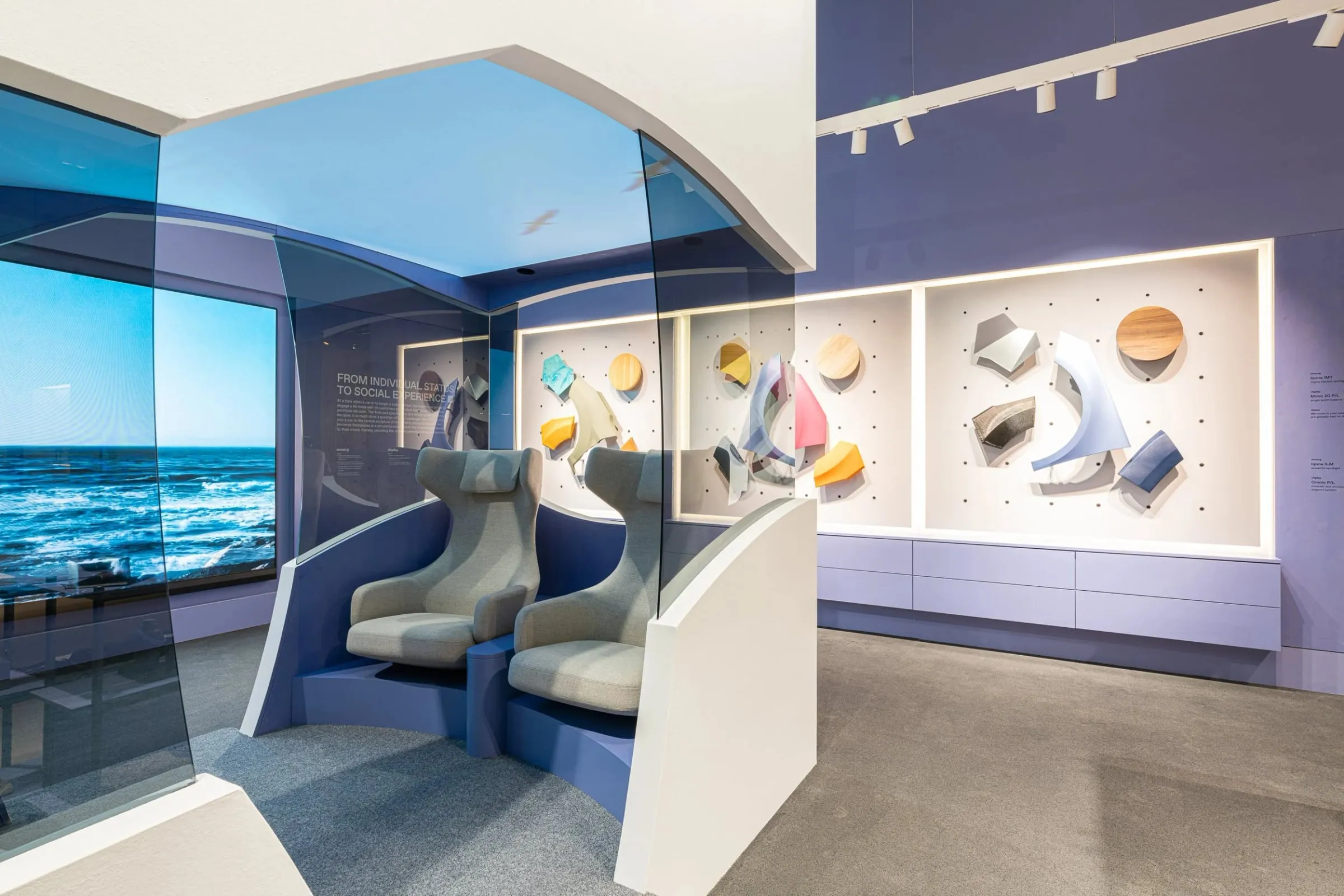 Messestand der Euroshop in Düsseldorf, Sitznische mit Loungesesseln vor Meeresbild, daneben Wandvitrinen mit Materialmustern