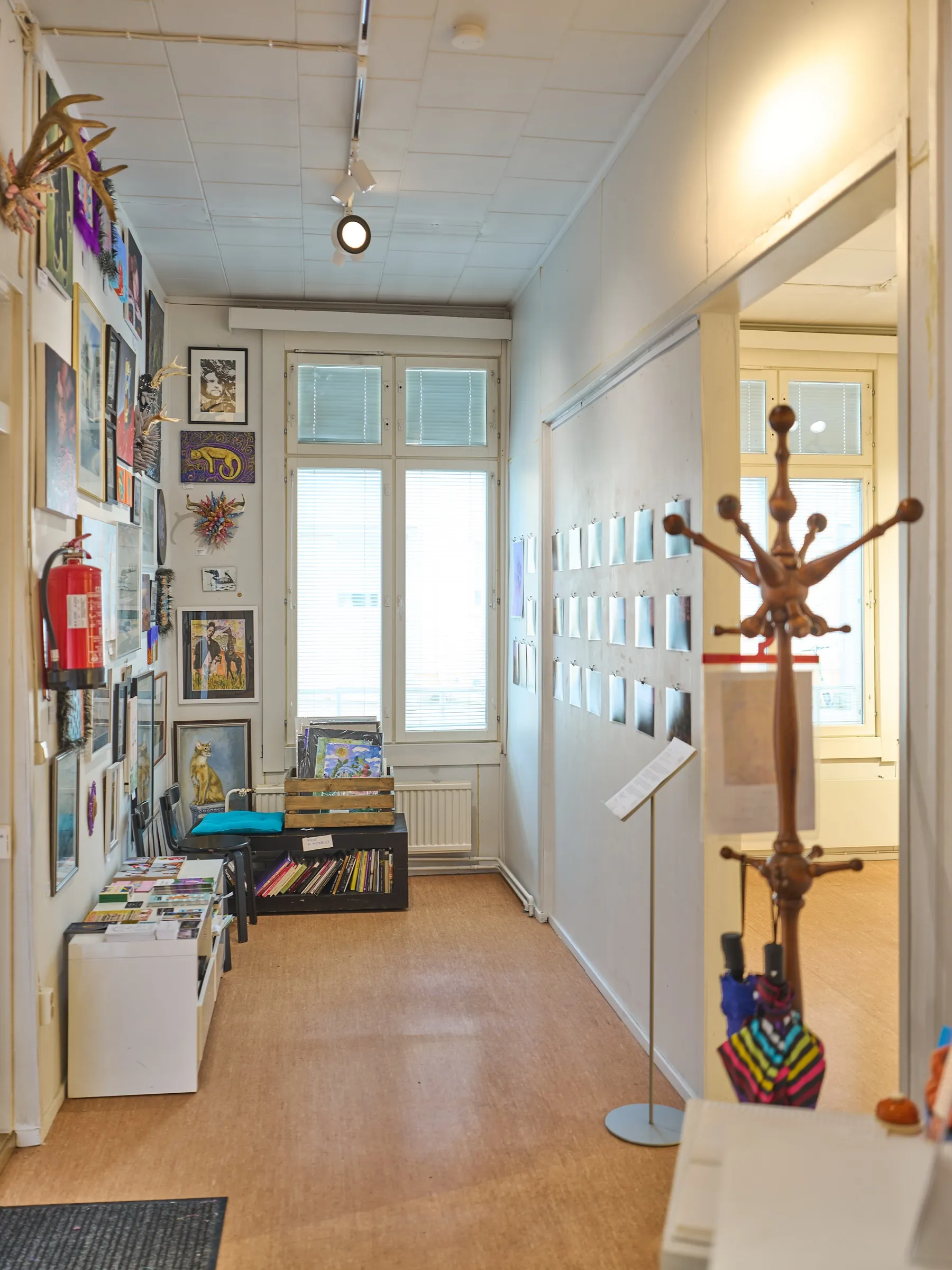 Gallery corridor with wooden floor and pictures on the walls, portrait format