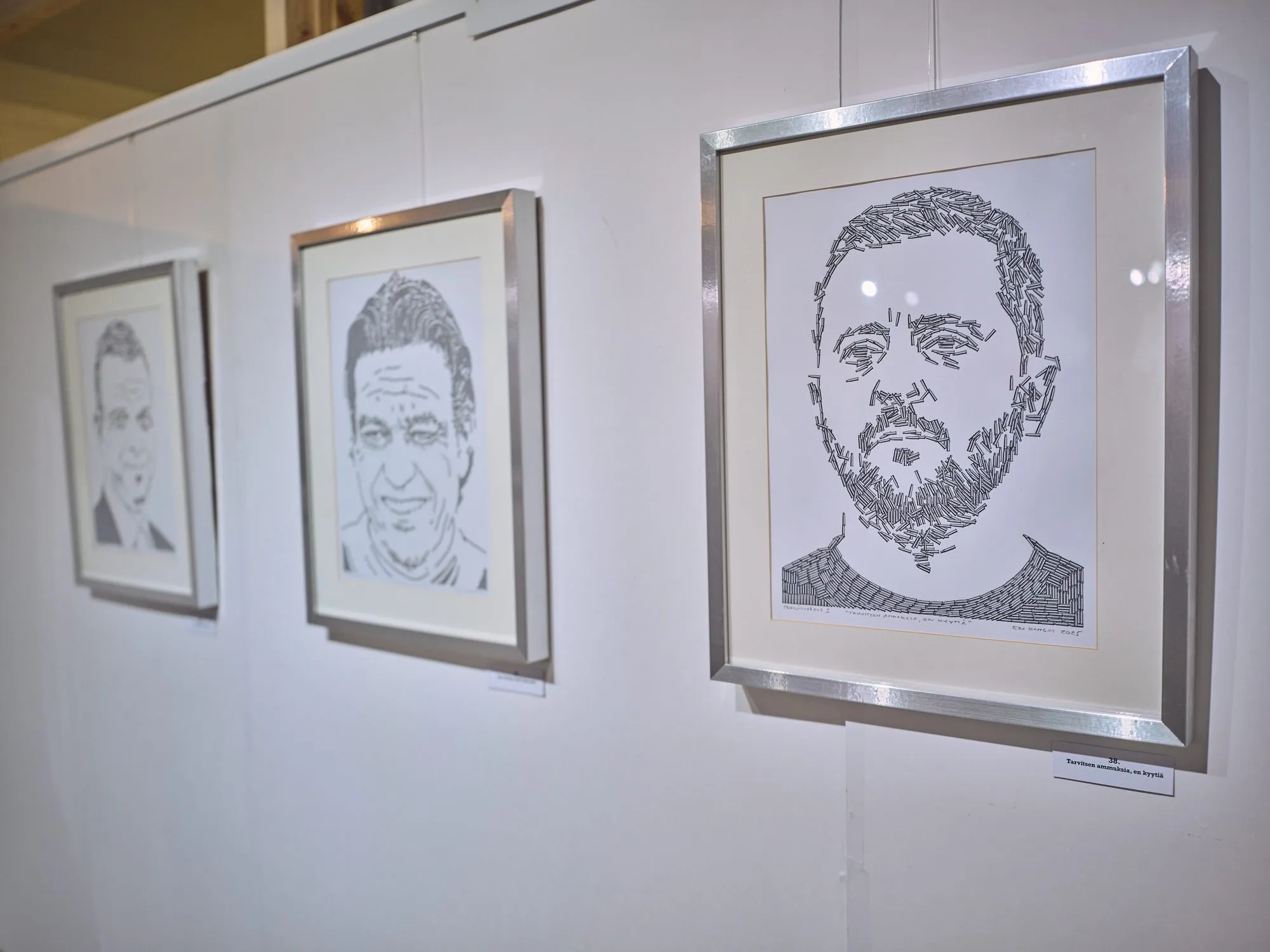 Portrait of Zelensky made of tiny cartridges, black on white, framed on a white wall