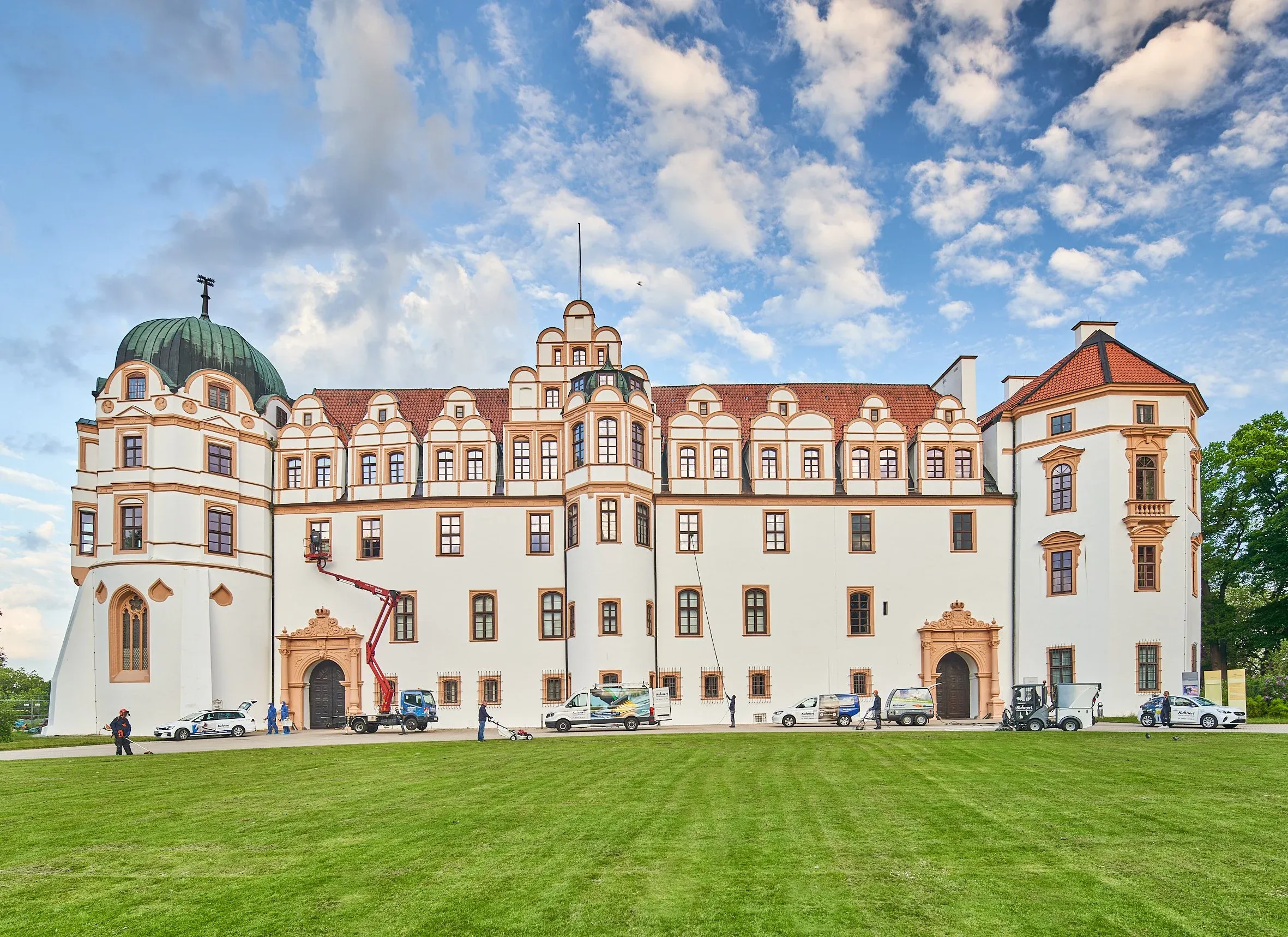 Luftaufnahme des Celler Schlosses, davor Fahrzeuge und Hebebühne von Kuhnert Gebäudeservice auf dem Rasen
