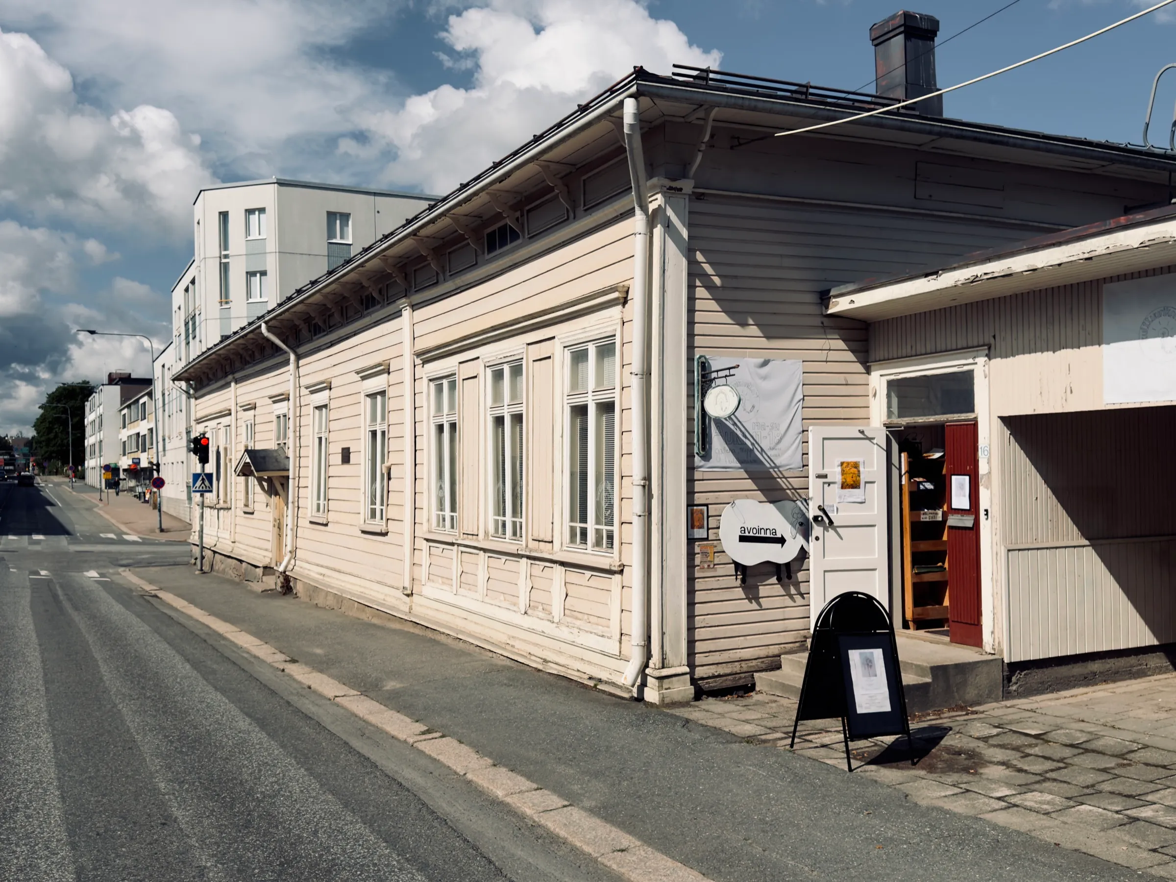 The old wooden house of Kulttuurikonttori in Hämeenlinna, trees and summer light in front