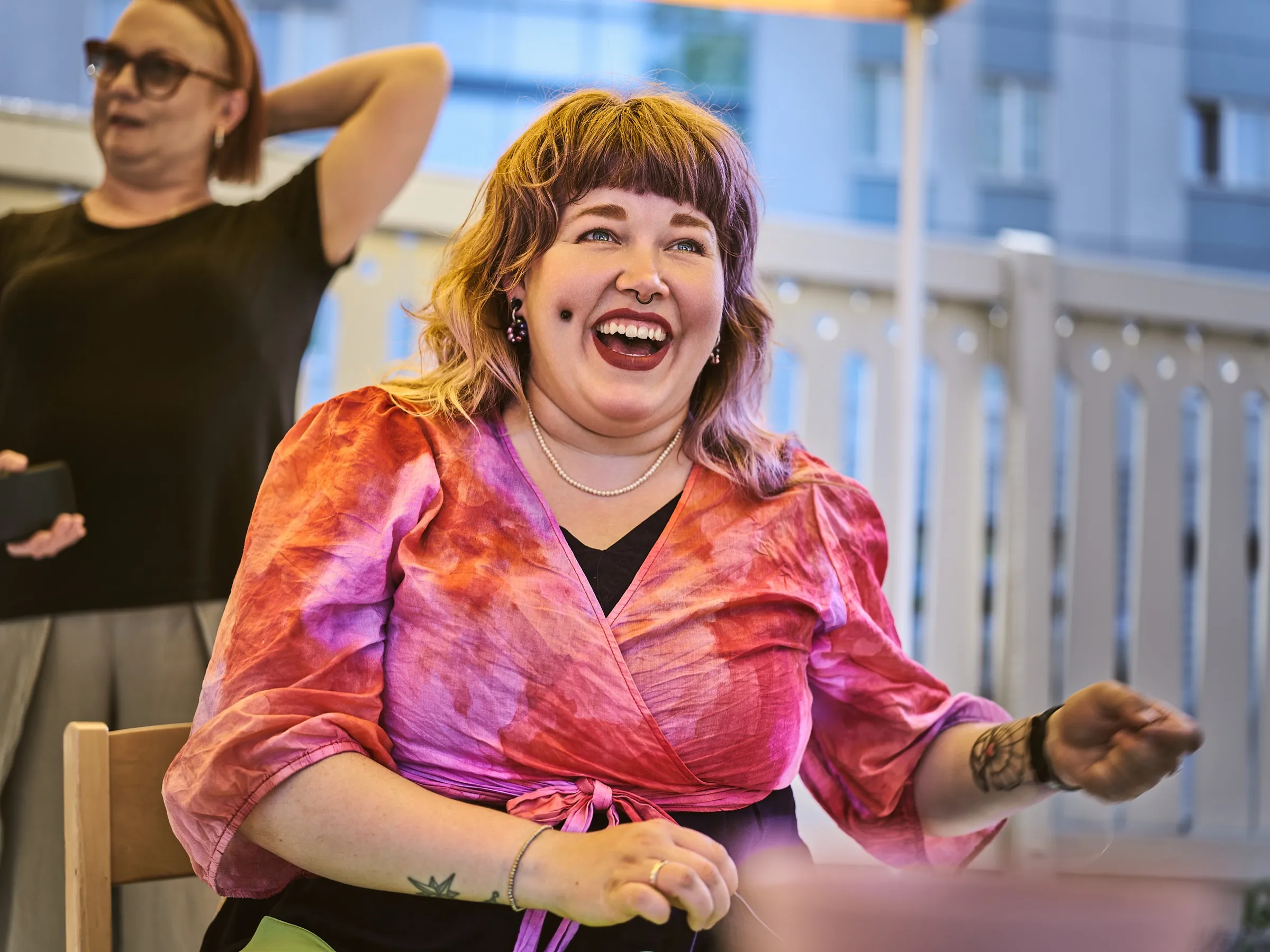 Laughing woman in a colorful dress sitting in the audience