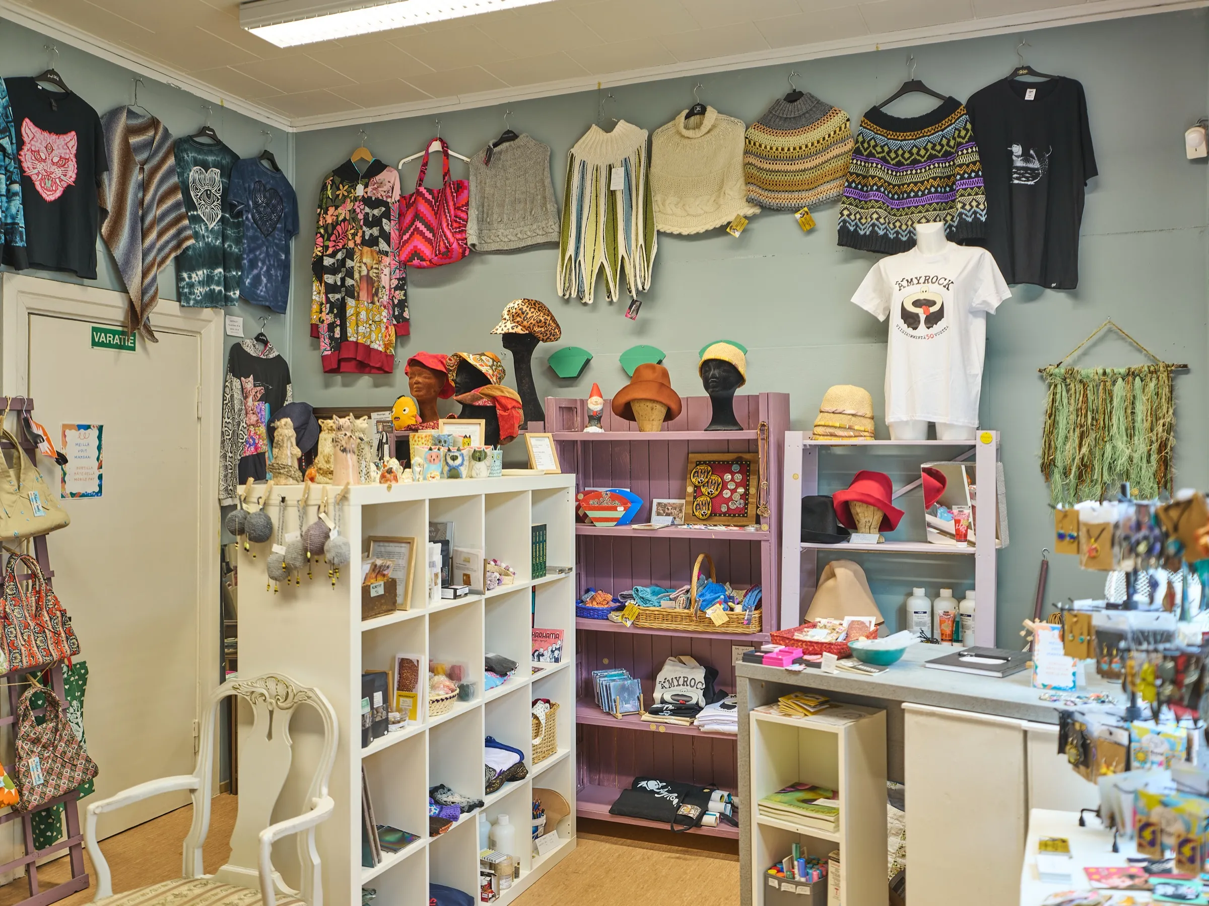 The small shop with handmade design: knitwear and shirts on the wall, hats, ceramics and shelves full of small things