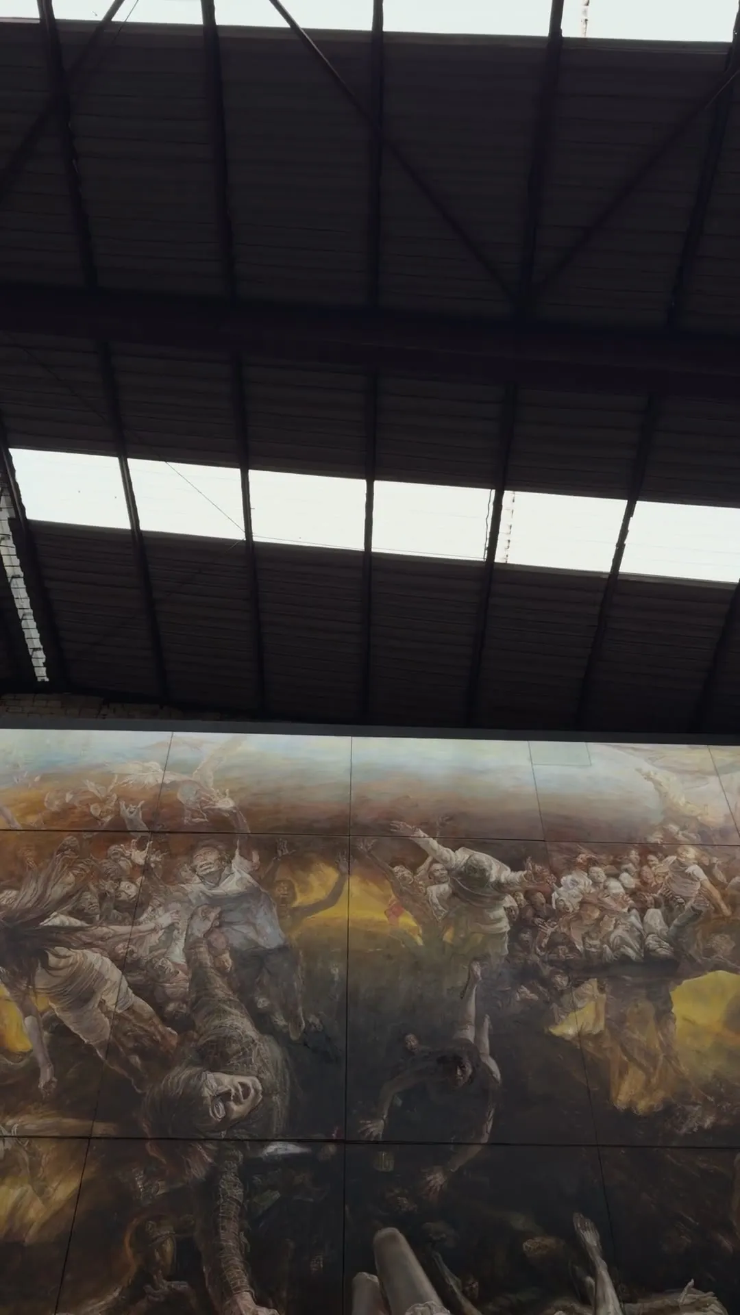 The camera glides over Liu Yaming's huge painting of tumbling bodies under the hall roof