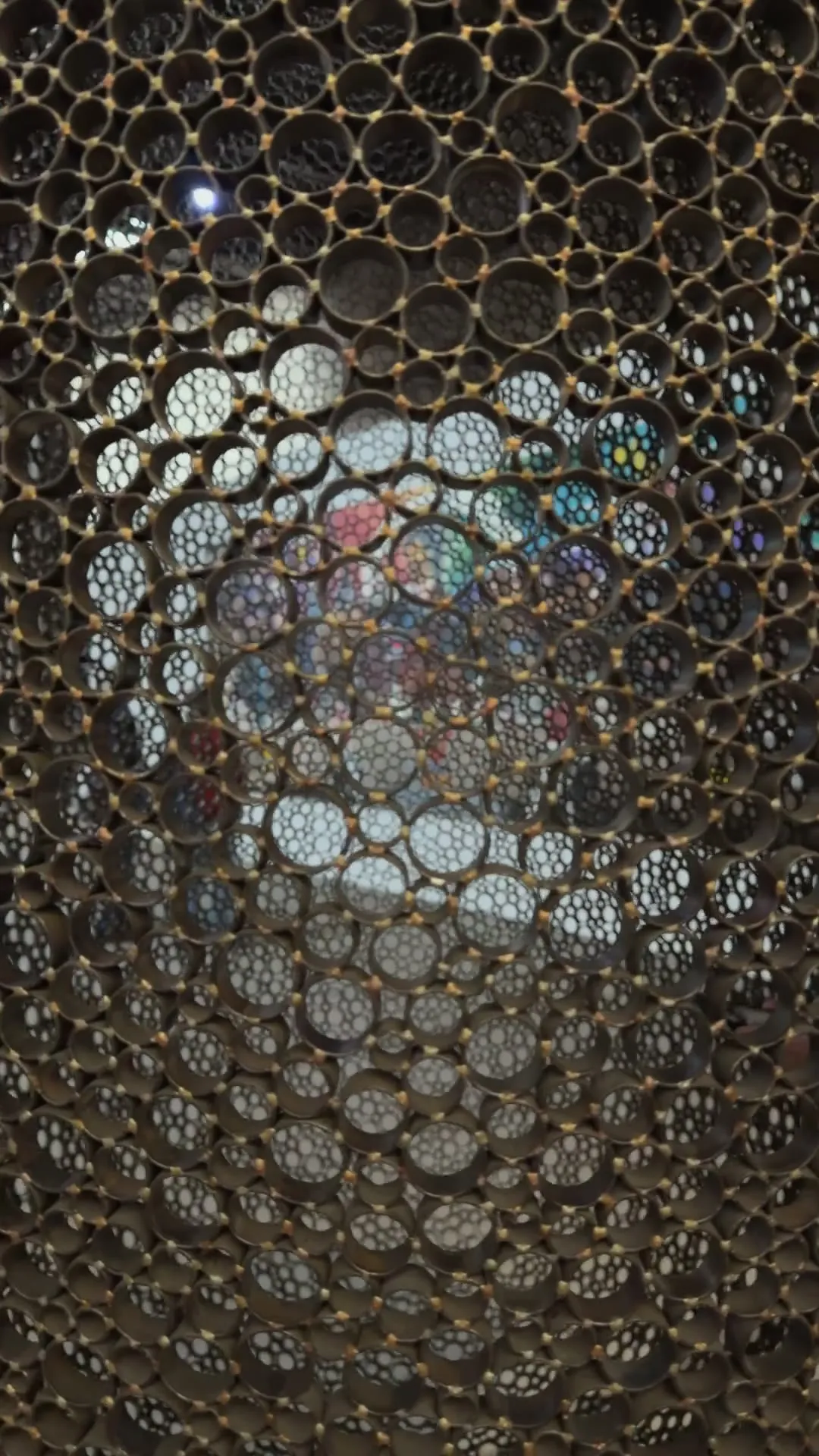 A close camera move over a surface of countless steel rings reflecting the light