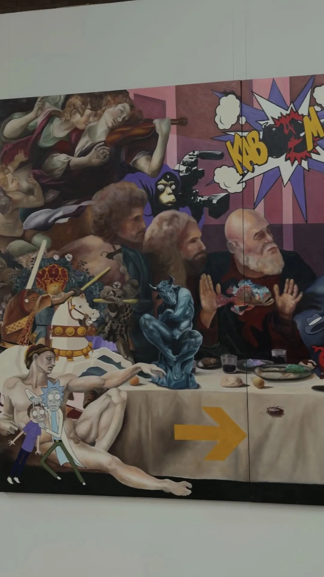 The camera moves along a long, colourful table painting full of figures