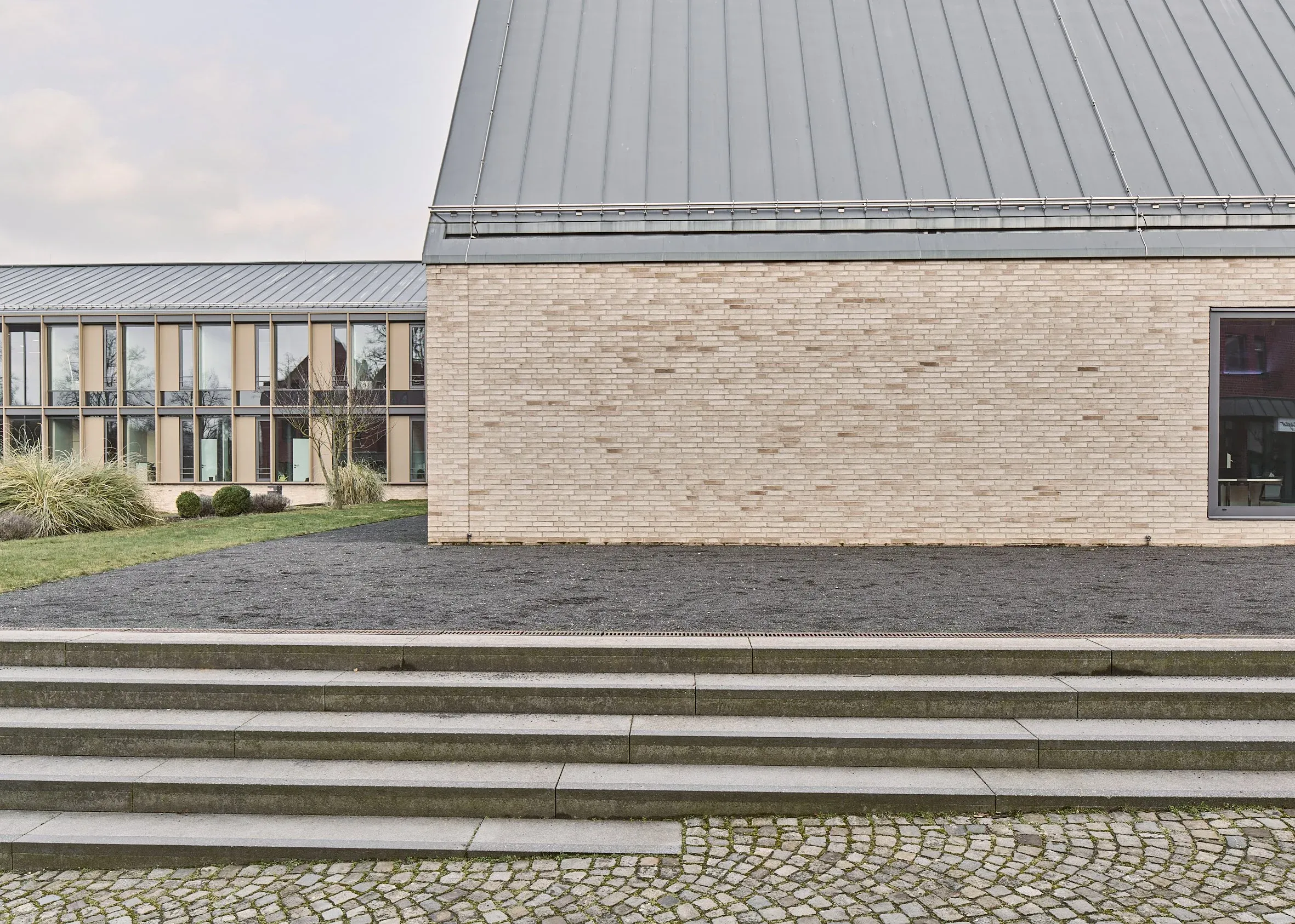 Rathaus Bissendorf von Blocher Partners, helle Klinkerfassade mit verglastem Trakt links und breiter Freitreppe im Vordergrund, Tageslicht