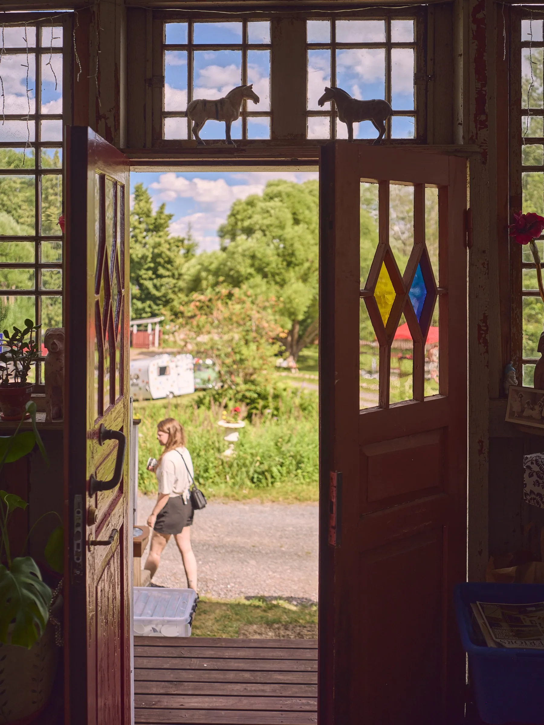 Open double door with coloured glass diamonds, view out into the summery yard, portrait format