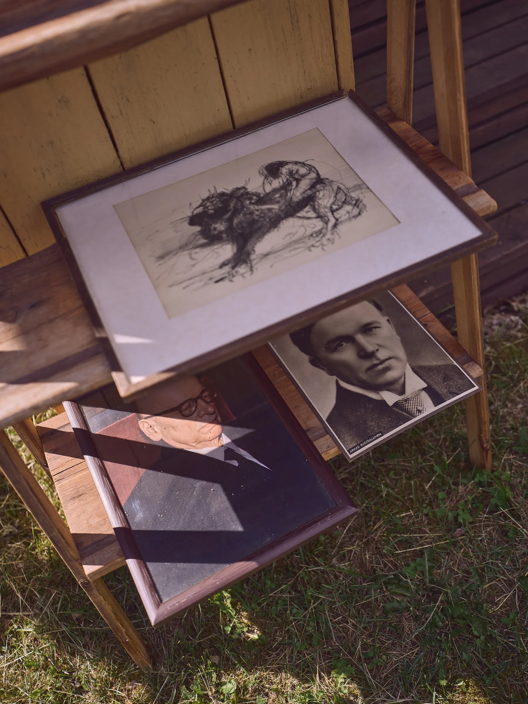 Shelf with a framed horse drawing, a black and white portrait of a young man below, portrait format