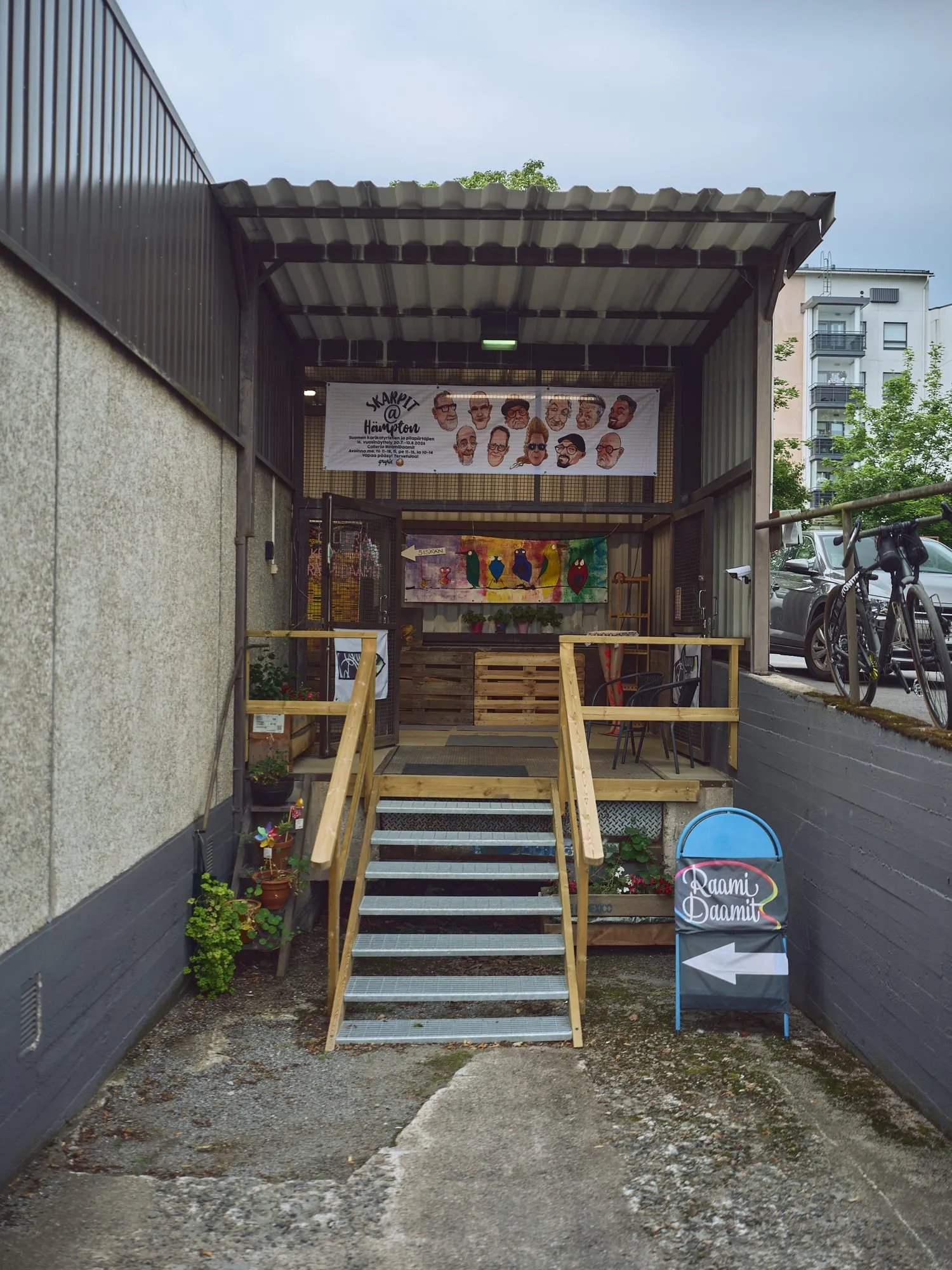 A narrow flight of stairs down to the gallery entrance below street level, portrait format