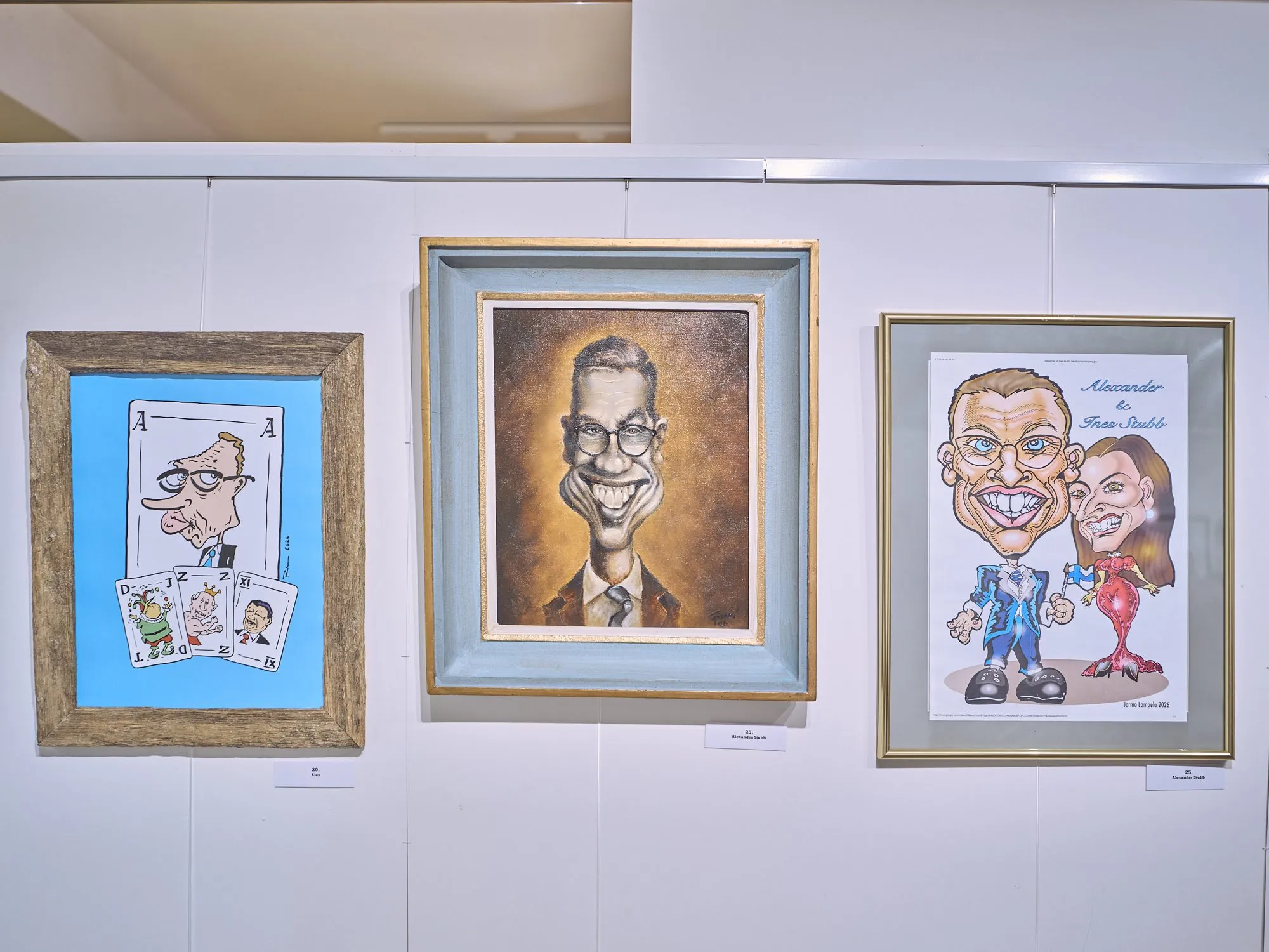 Three very different caricatures of Alexander Stubb side by side on a wall