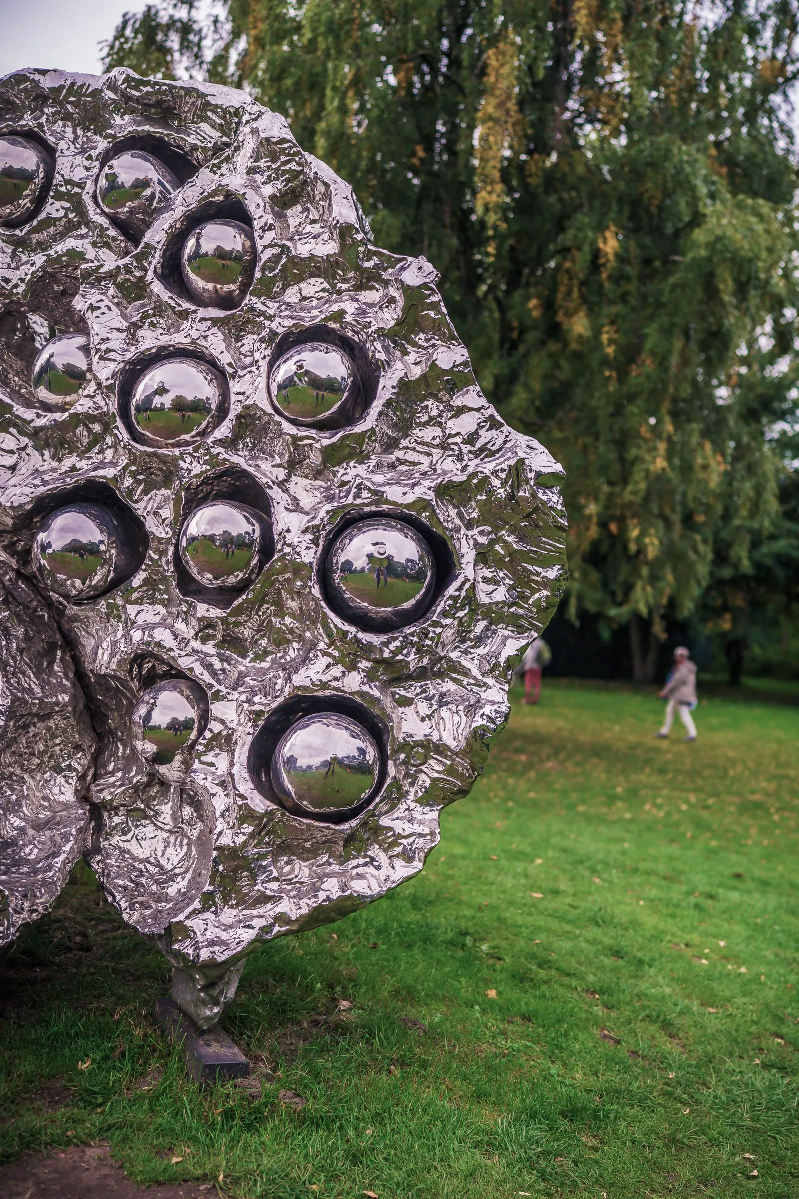 Close-up of a silver sculpture like a lotus seed pod, mirrored spheres in its hollows