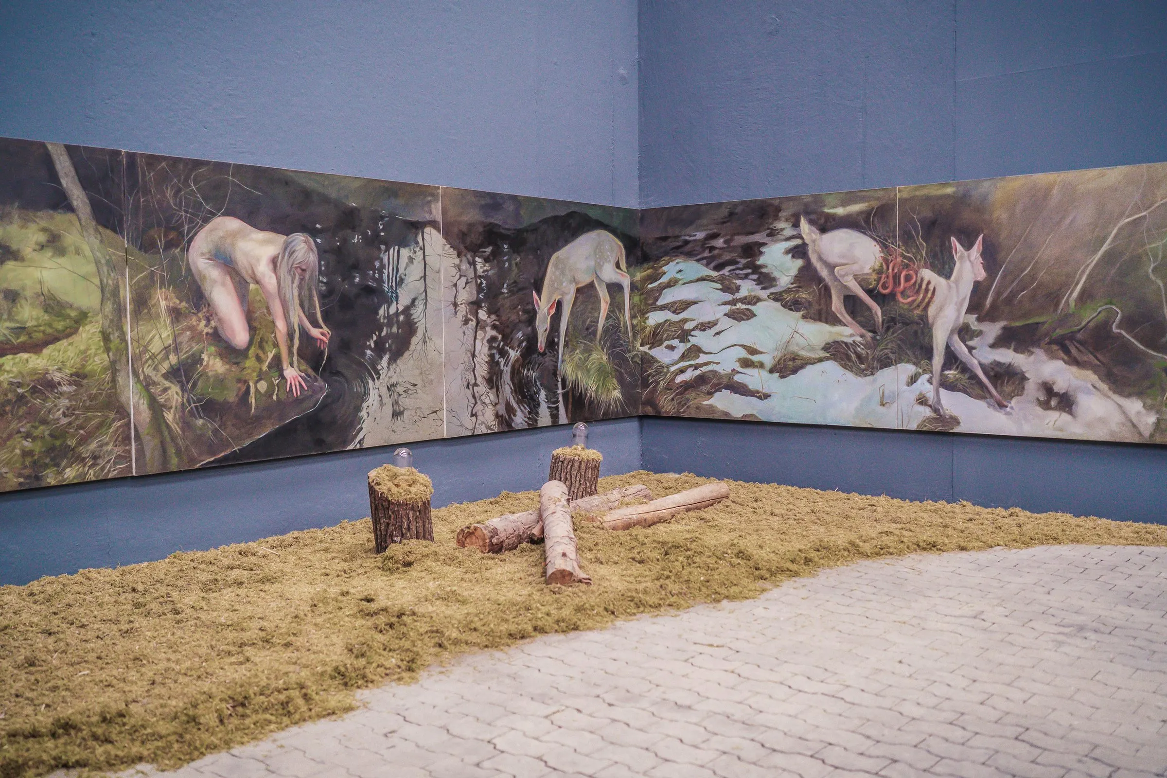 The panoramic painting in detail, tree stumps and pieces of wood on hay in front
