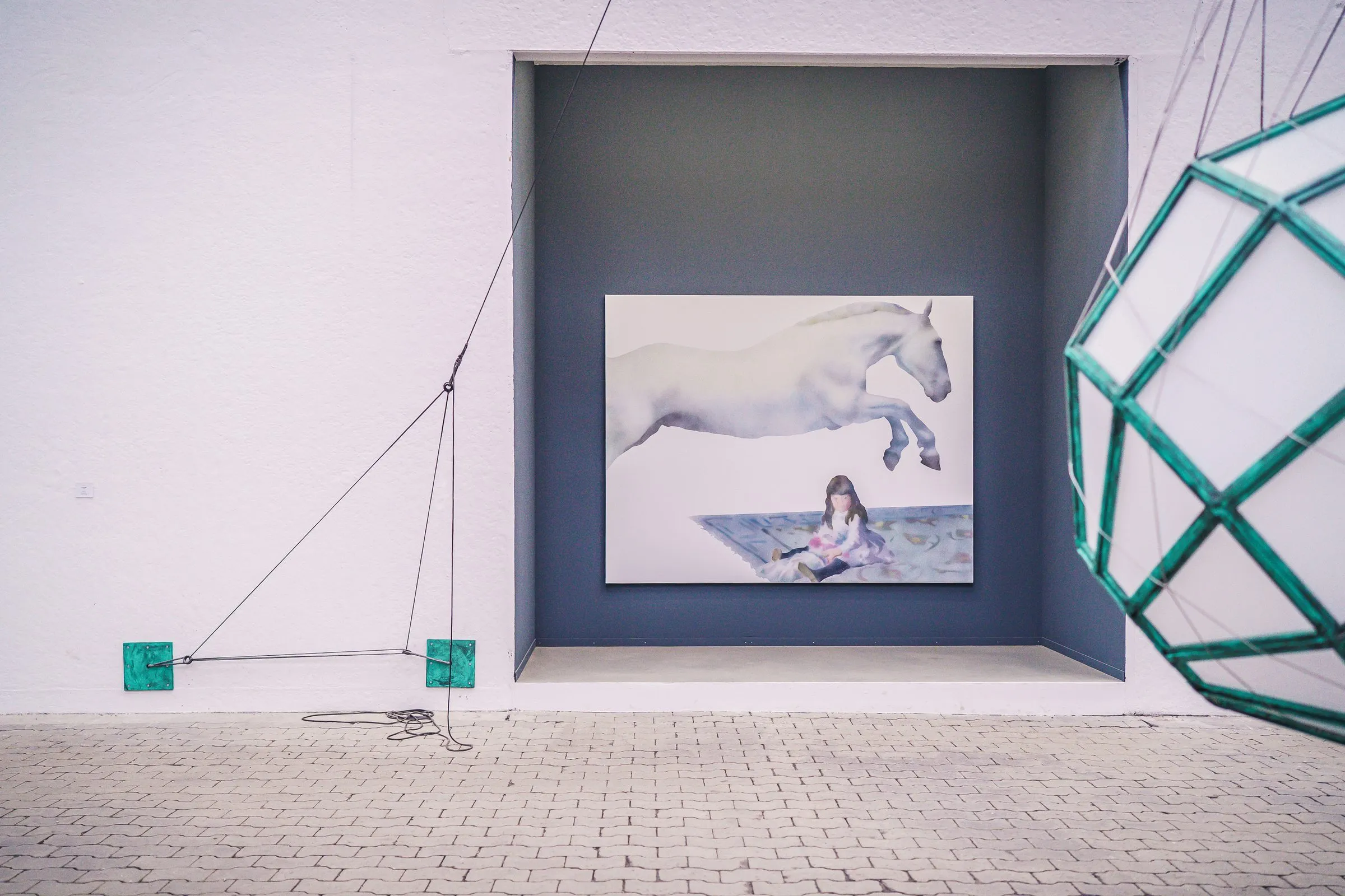 A painting with a leaping white horse and a girl in a dark blue niche, a green lattice object on the right