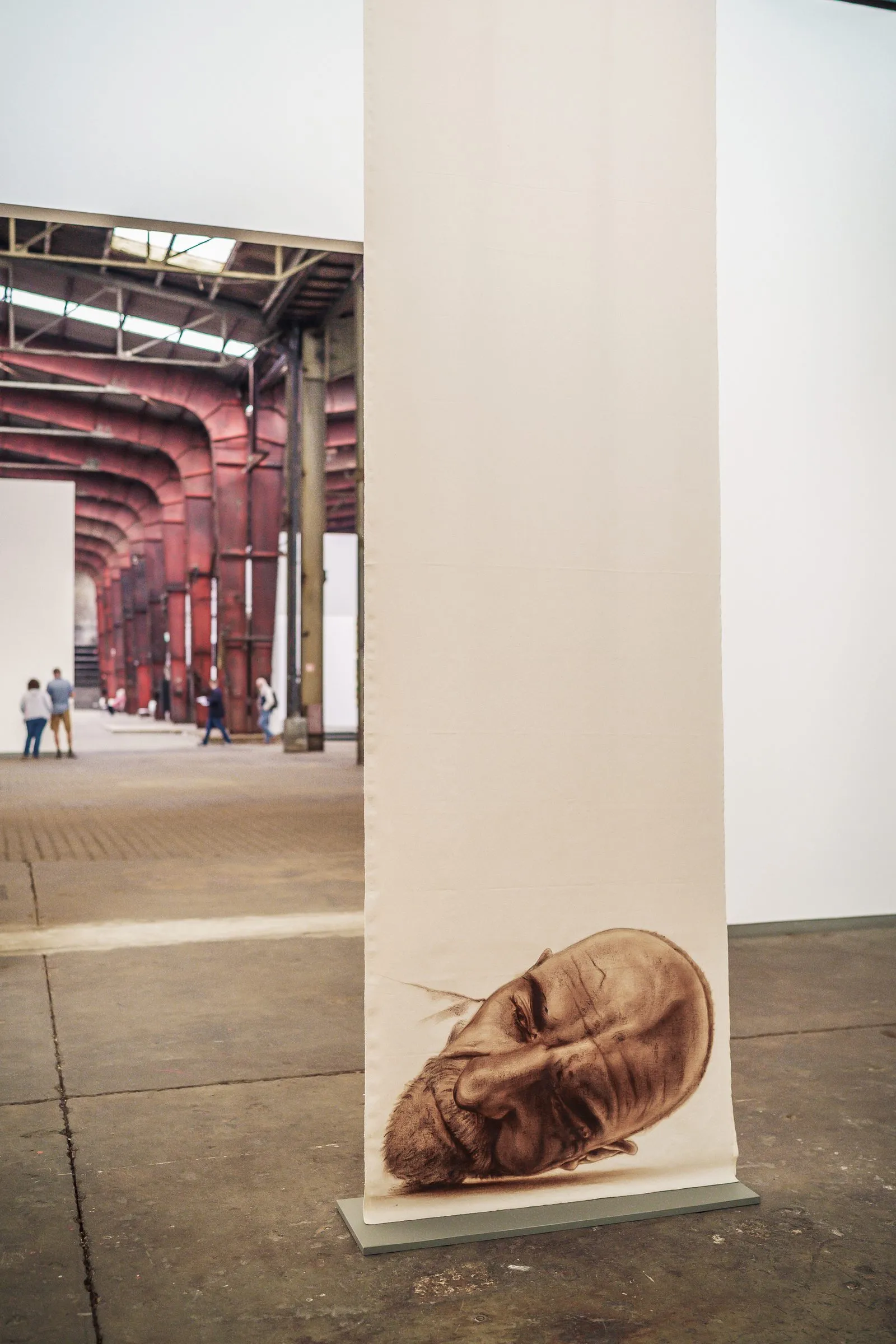 Portrait: a single fabric banner with a sleeping face, the hall behind