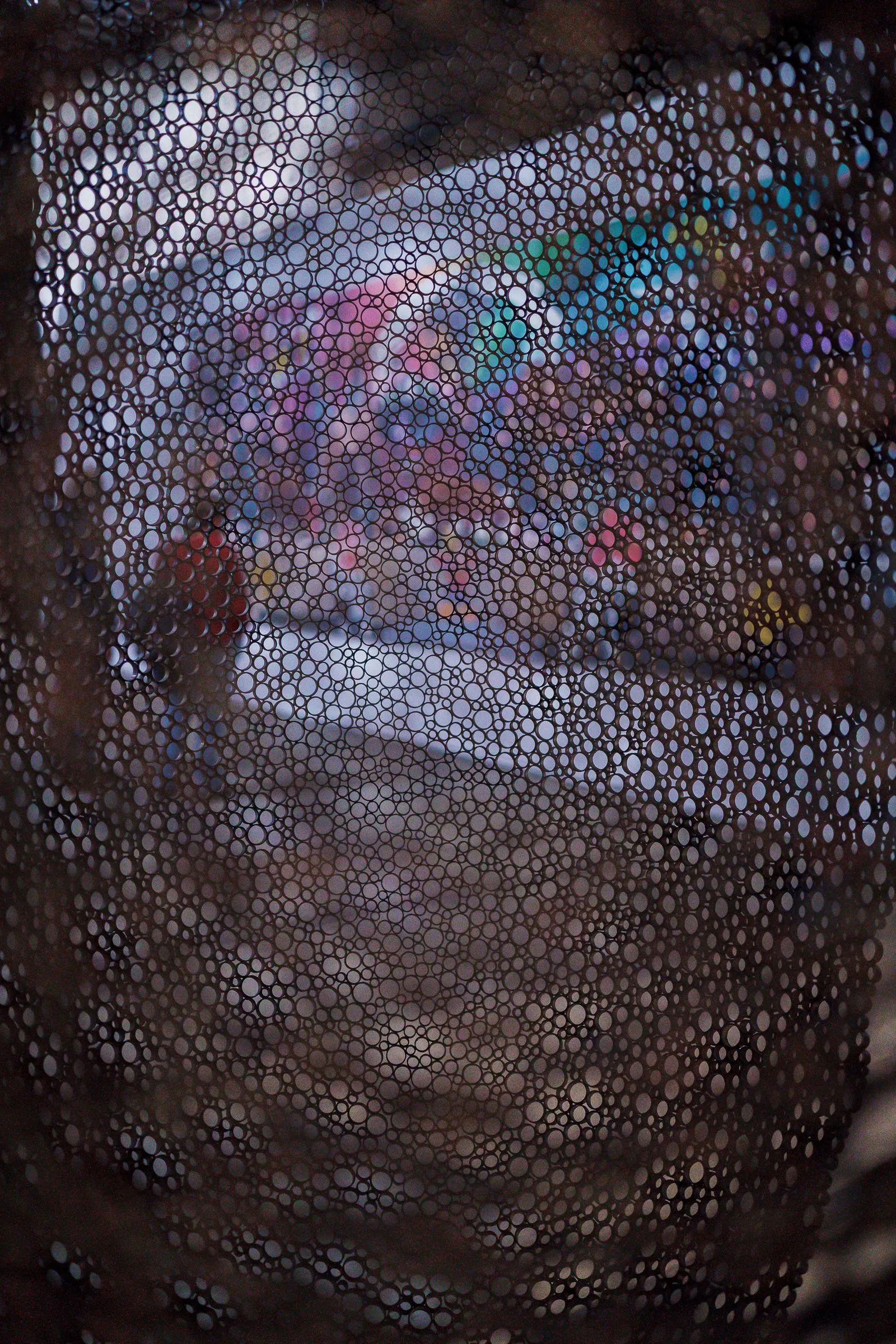Portrait: close-up of a surface made of many small, shiny rings in red, blue and white
