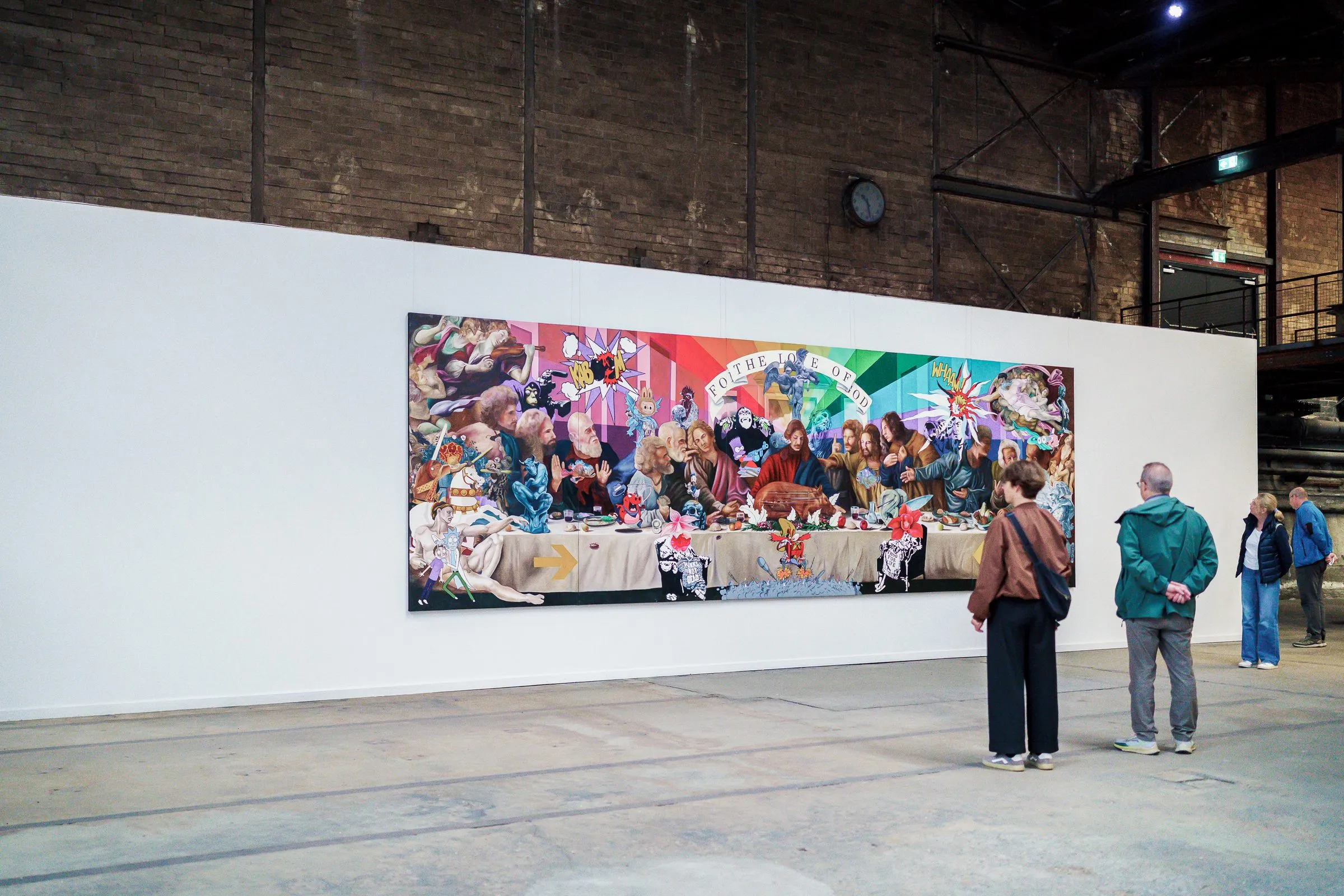 The wide, colourful table painting from a distance, several visitors in front