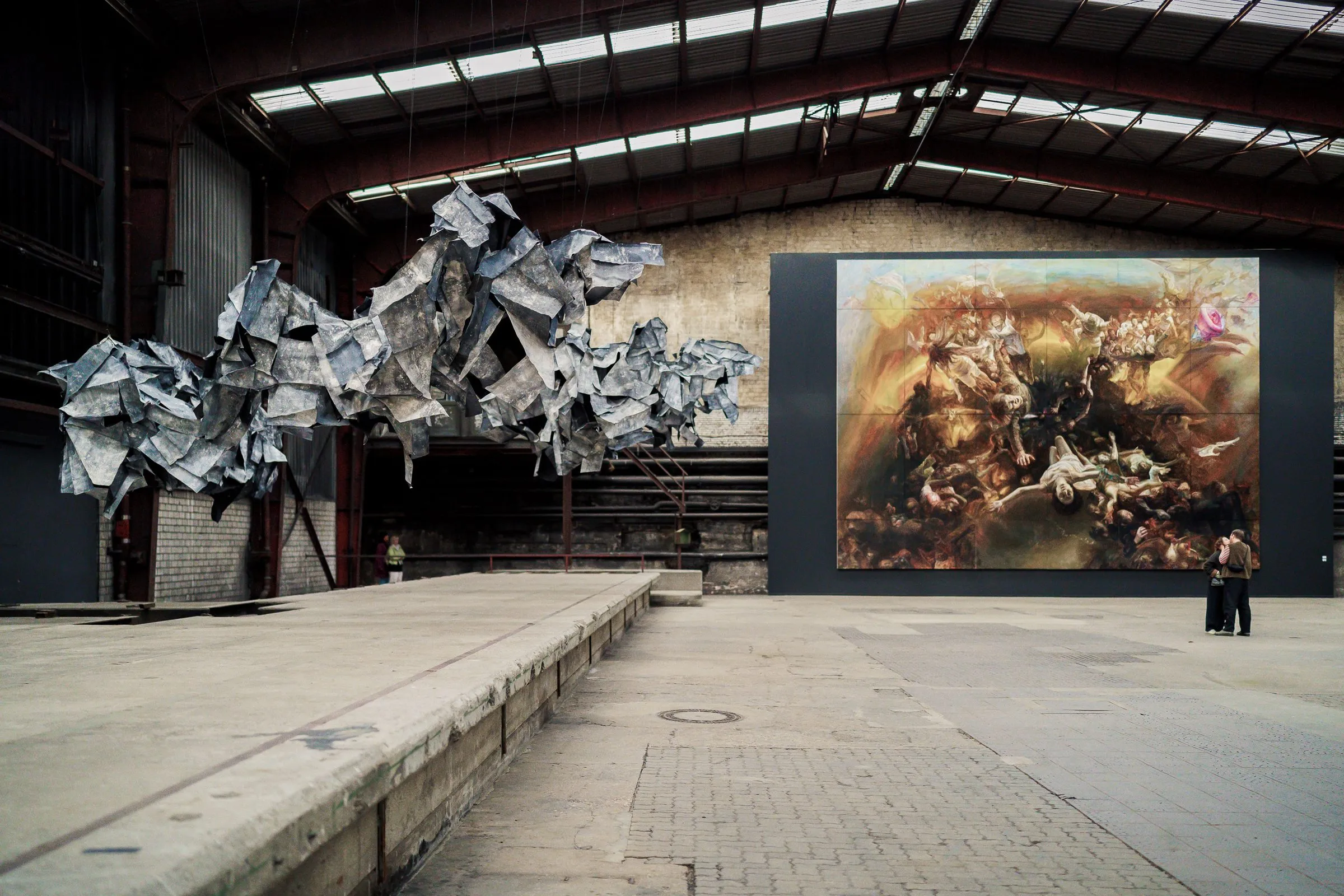 Silver metal clouds float on the left, the large painting on the right, the hall in between