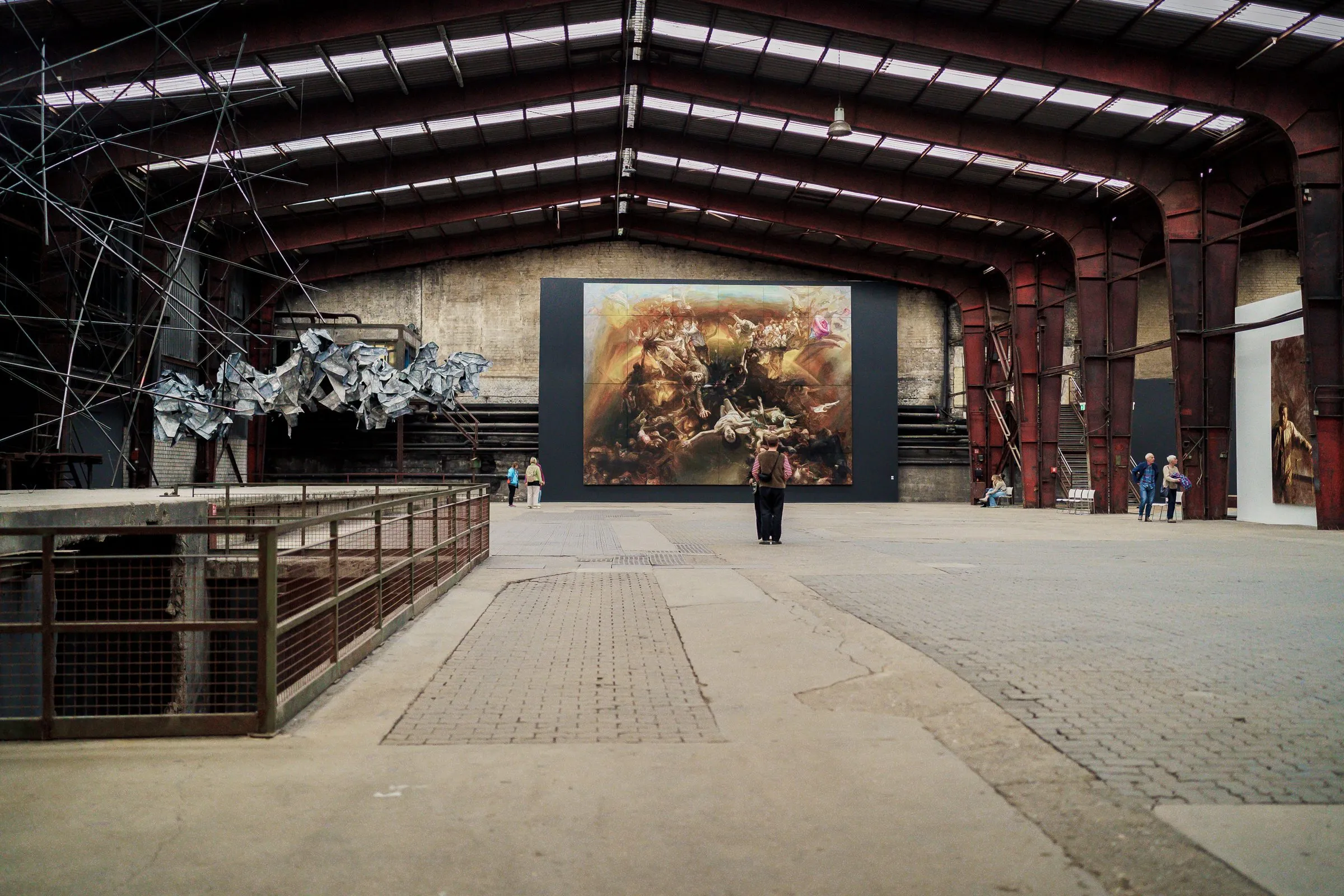 The painting at the end of the hall, a railing and a net of ropes under the roof in the foreground