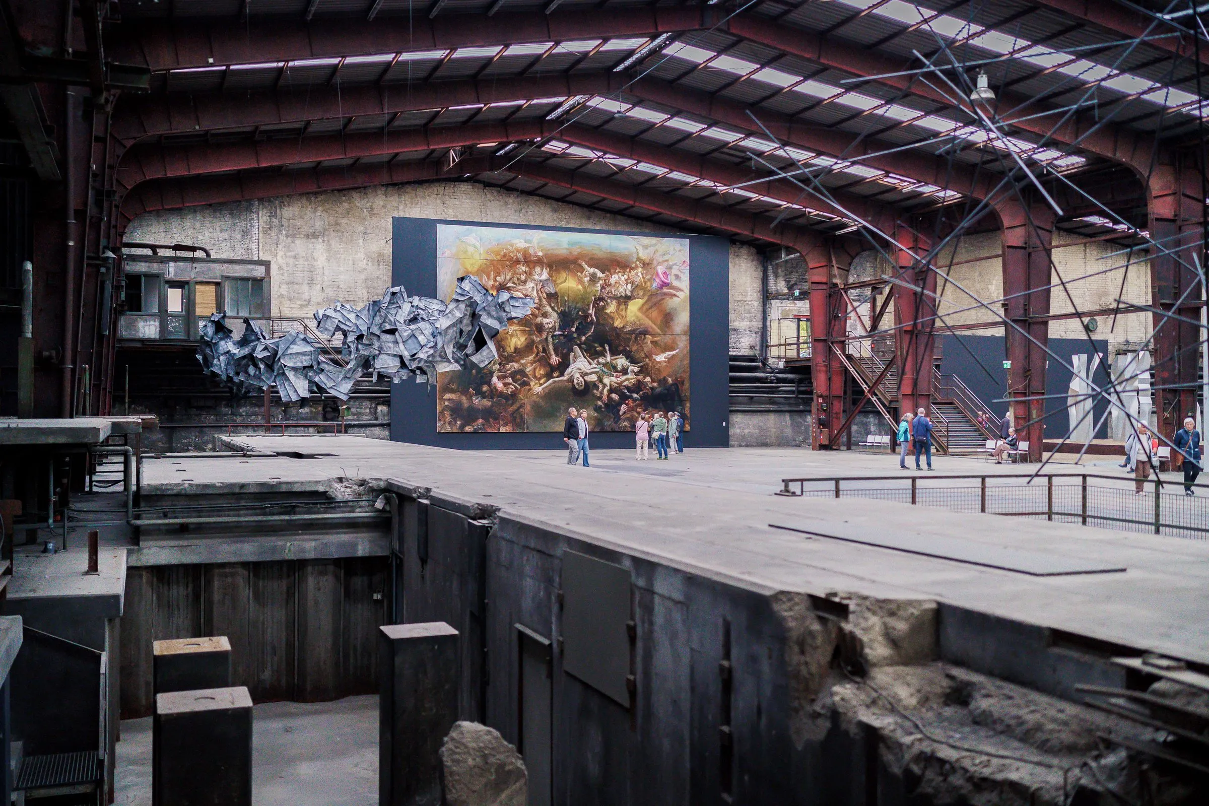A view across an old casting pit with wall remains towards the painting at the end of the hall