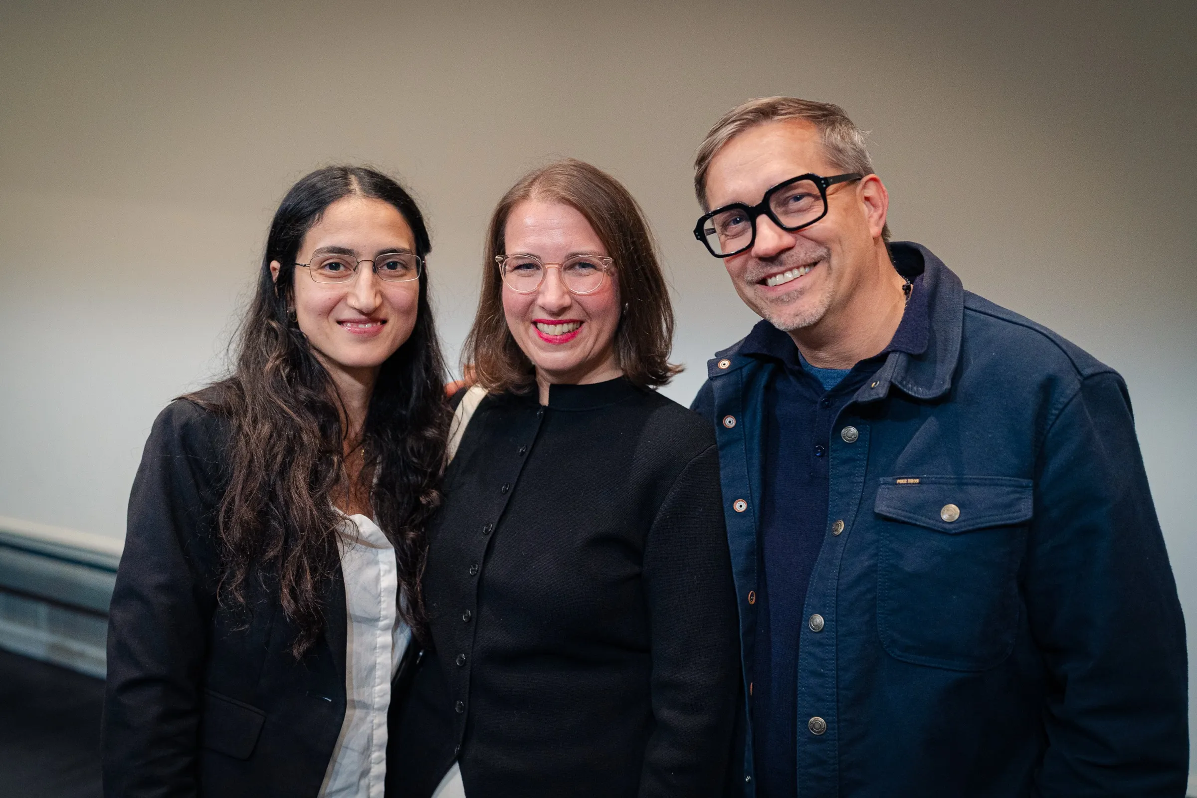 Leyla Yenirce, Dr. Anna Heinze and Roman Thomas standing close together, laughing into the camera