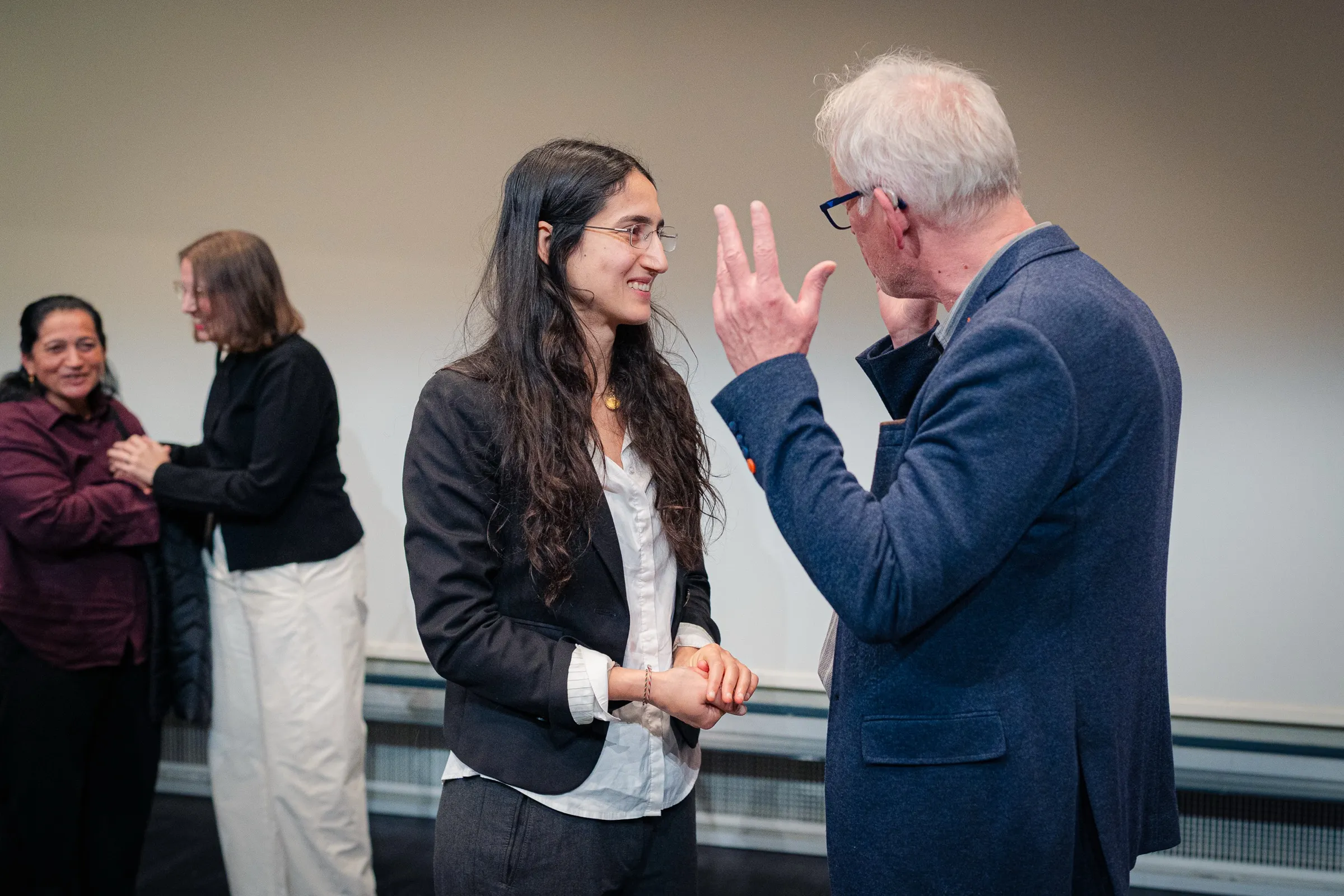 Conversation in the hall after the award, a guest with white hair gesturing lively