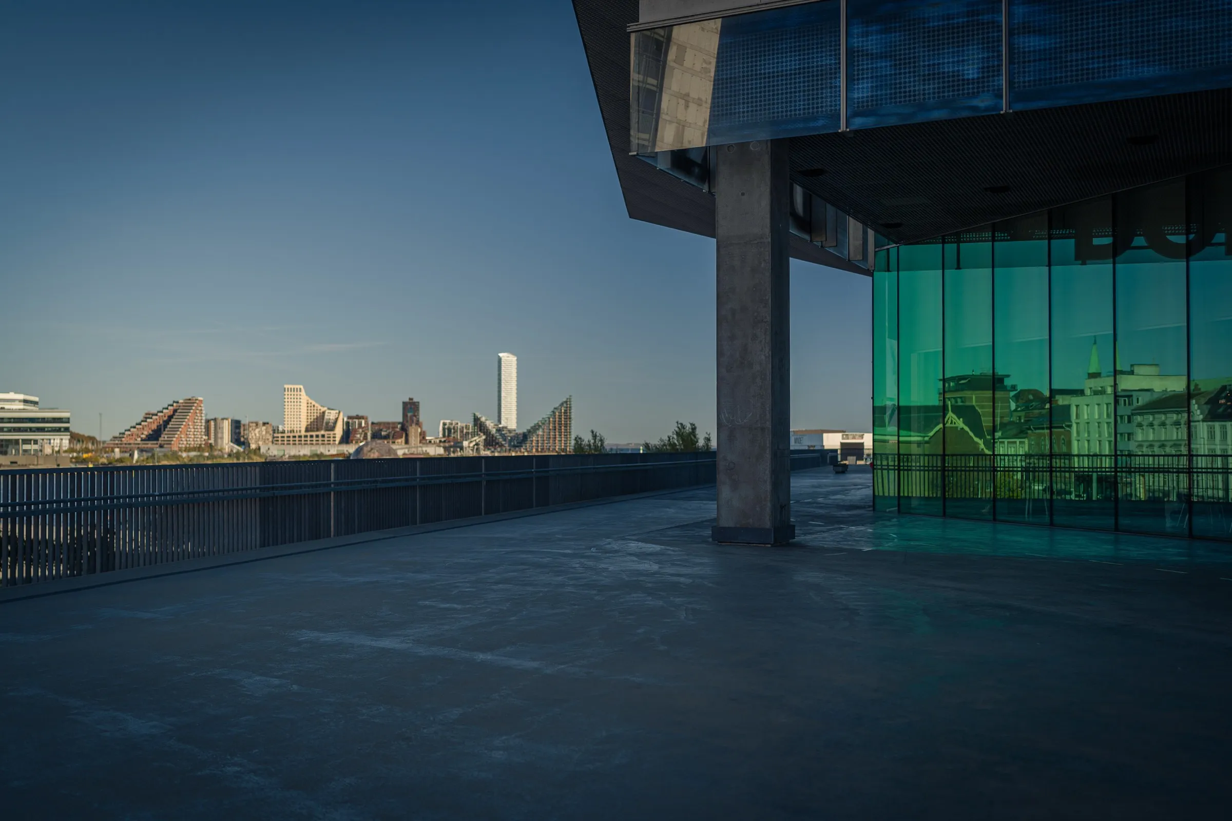 View beneath the cantilevered roof of Dokk1 towards the skyline of Aarhus Ø, a column on the right