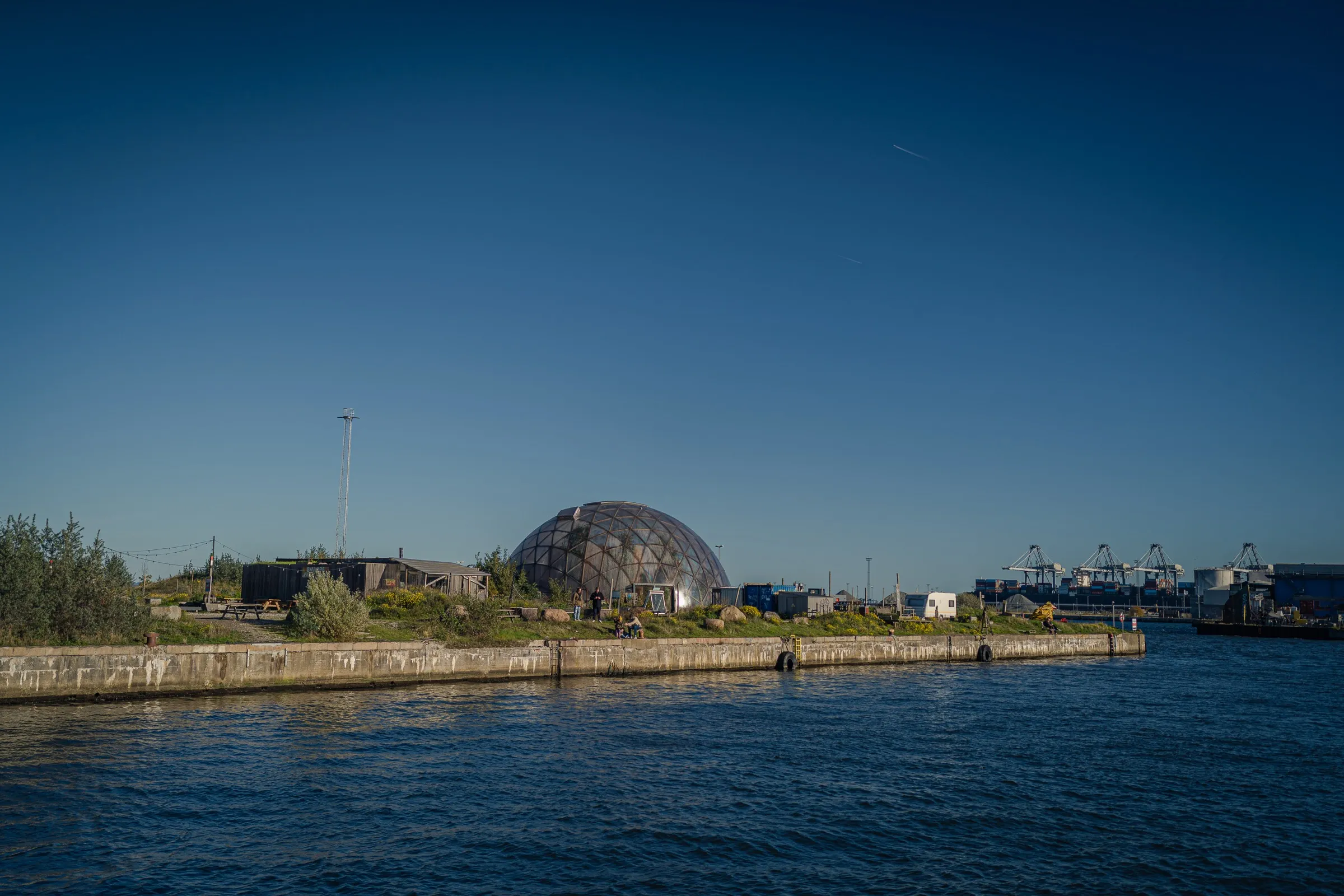 The dome behind a green shore, calm blue water in front