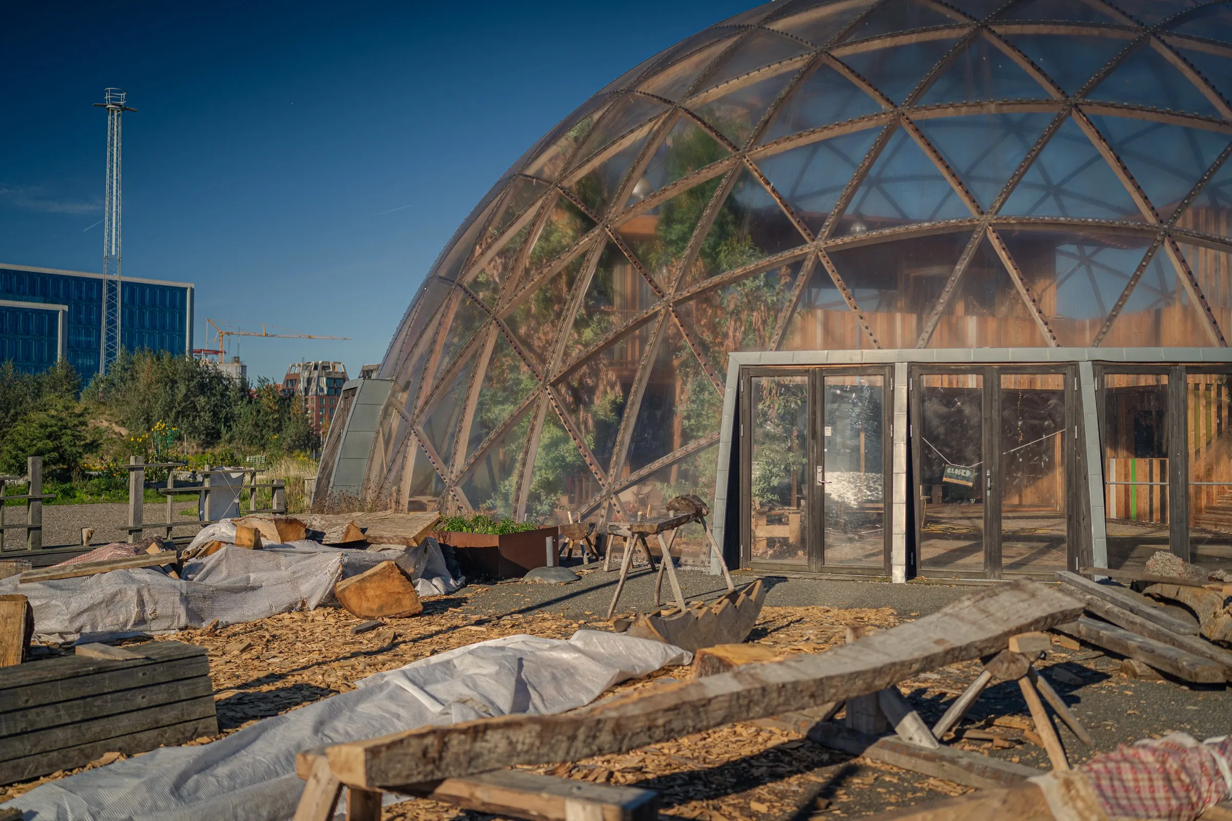 The dome with its entrance, tarpaulins and wood on the ground in front