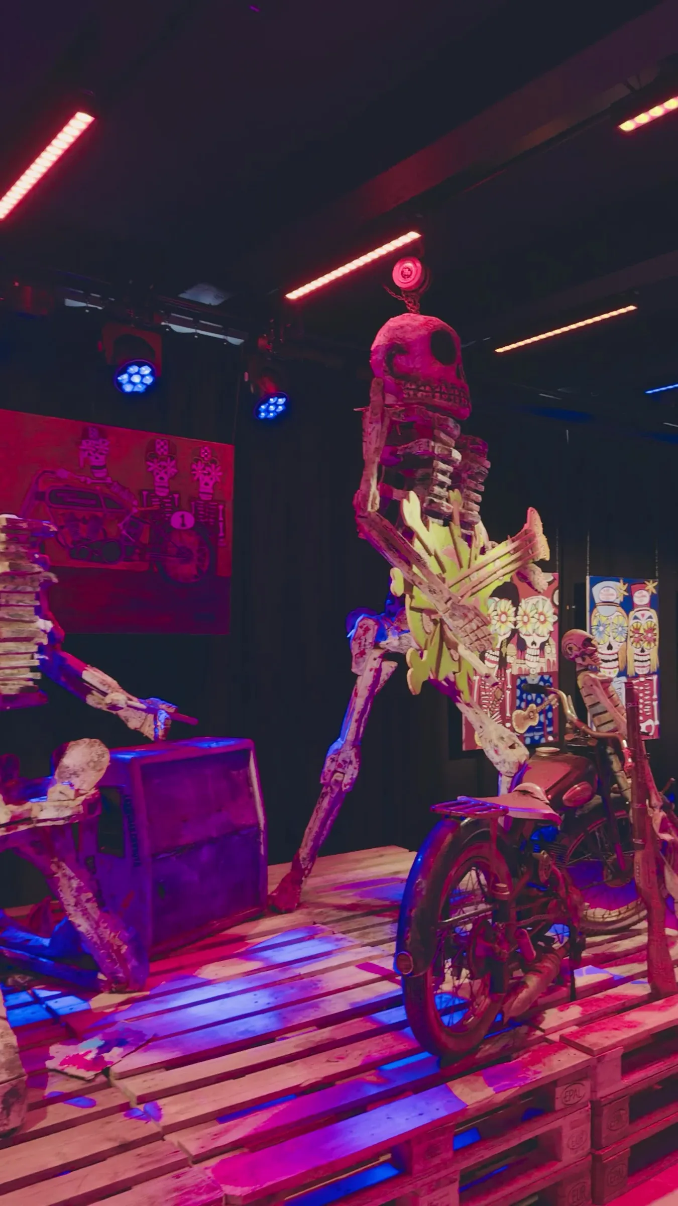 Video: painted skeleton figure on a bike, lit pink