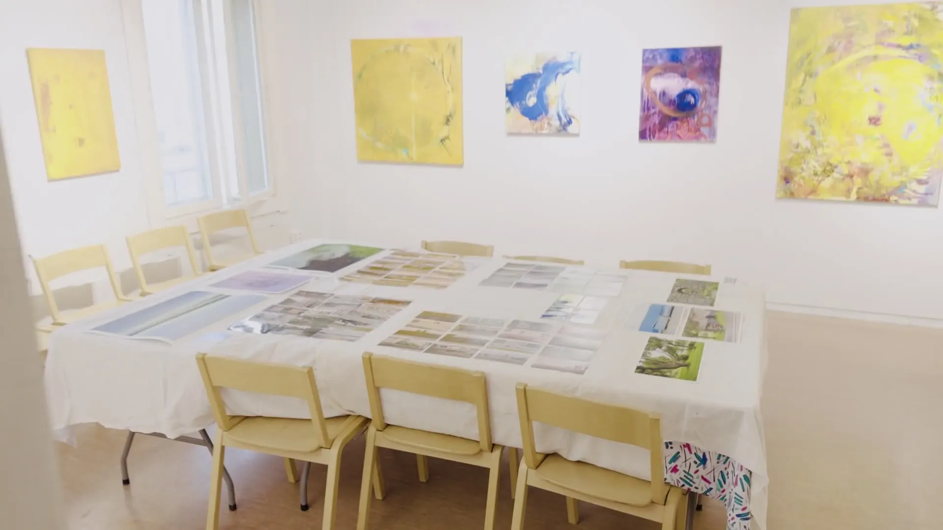 Video: pan across the long table with the prints laid out in the bright room