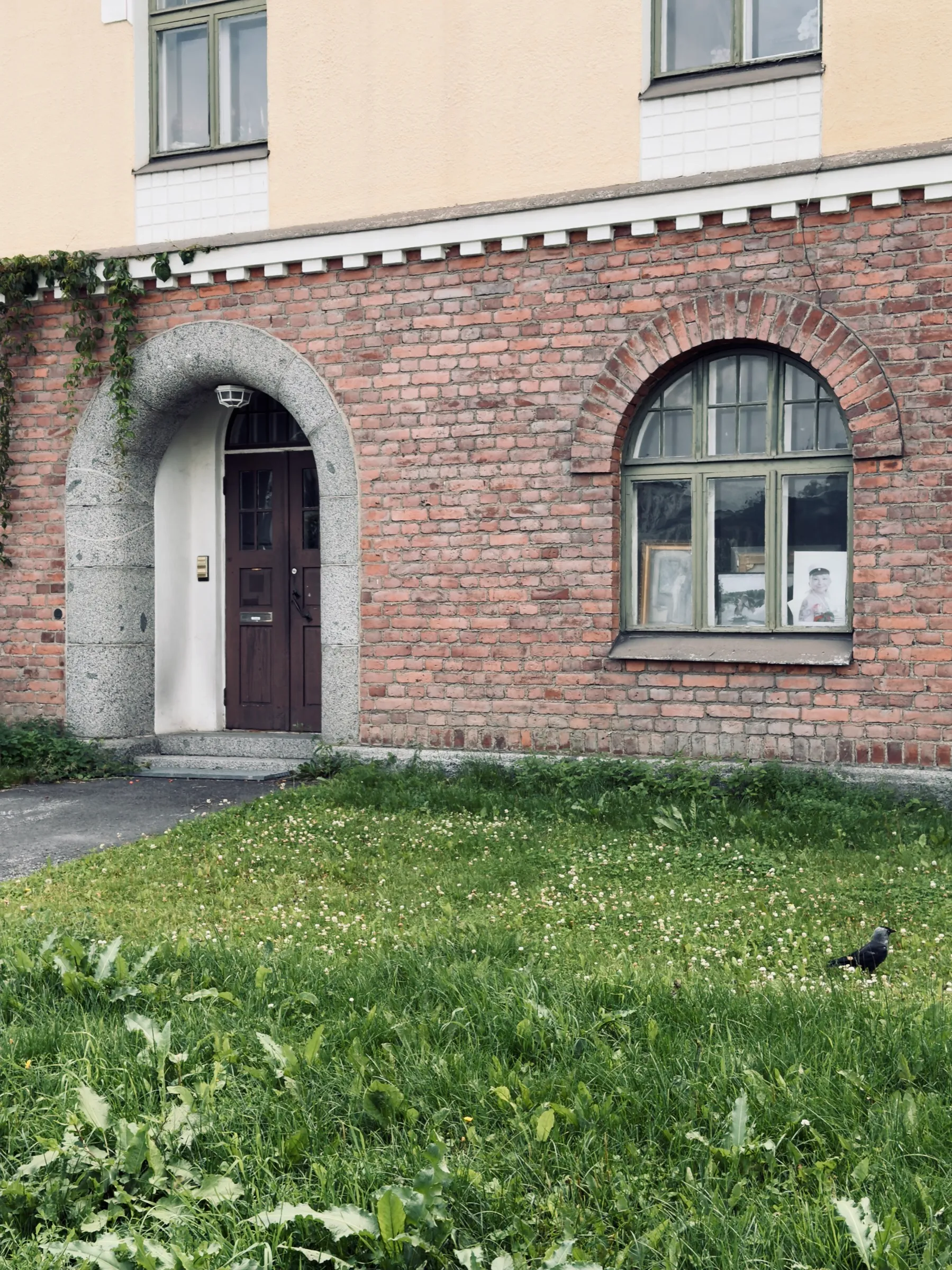 Entrance with granite arch and dark wooden door in the brick ground floor